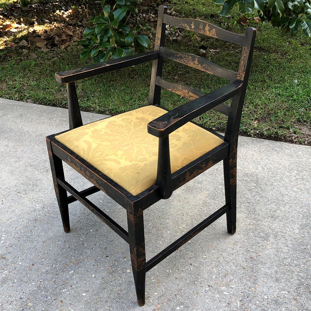 Antique chinoiserie armchair is a charming example of the Asian influence on European furnishings, with a tailored architecture, ebonized finish and hand painted gold scenery on almost every facet. Rich damascene silk upholstery completes the look,