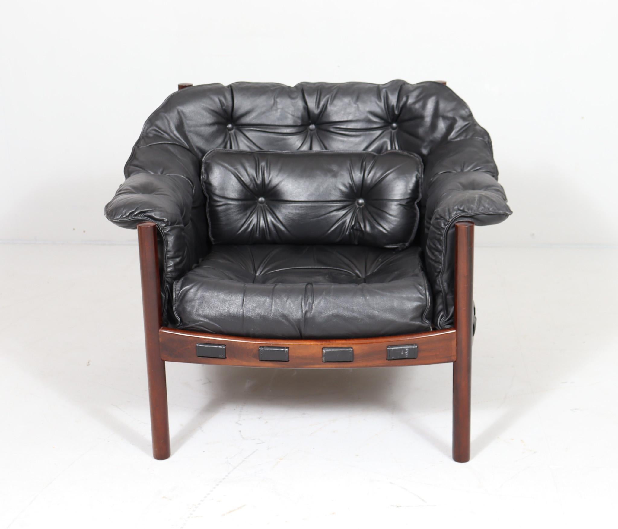  Comfortable armchair designed by Arne Norell for Coja,  made in the 1960s. in Sweden. 
Black leather padded cushions draped in a dark stained wooden frame. Good original condition 