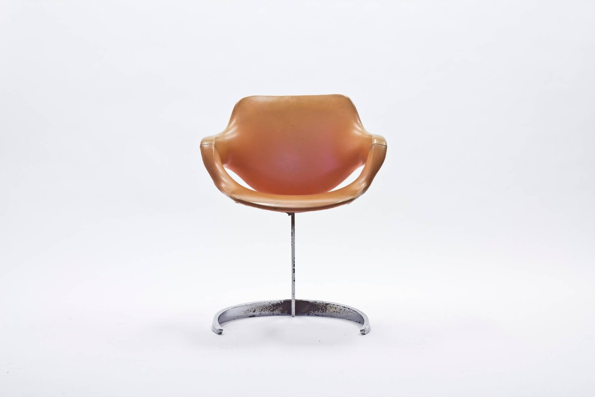 Scimitar armchair designed by Boris Tabacoff during the 1960s for French firm Mobilier Modulaire Moderne. A steel base in a scimitar style holds up a leather seat and back. The base features a bit rust and there is some wear to the leather parts.