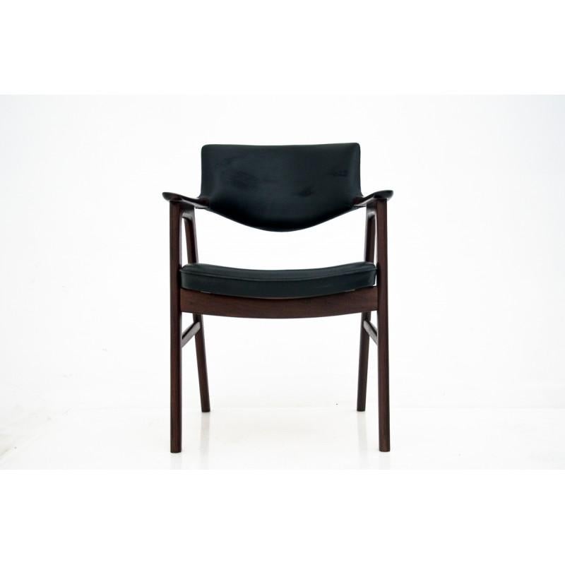This faux leather (skai) armchair was designed by Eric Kirkegaard in the 1960s in Denmark. It is made of rosewood, it is covered with original black leather upholstery. It is in very good condition. The wooden elements have been renovated.