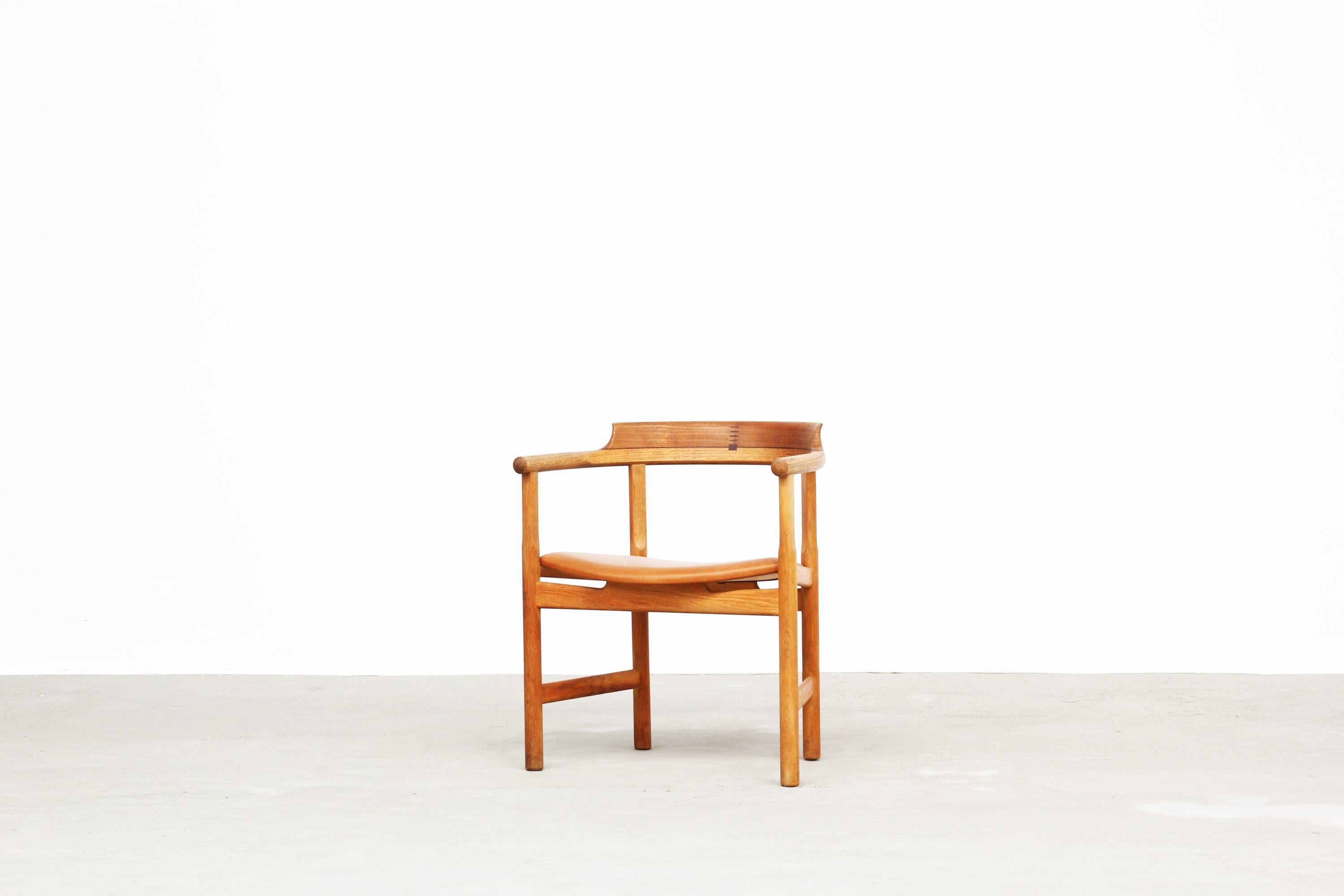 Beautiful armchair designed by Hans J. Wegner for PP Mobler, Denmark in 1975. The chair is in a very good condition without any repairs or damages. The frame is made of classical oak and the seat is newly reupholstered with brown-cognac leather.