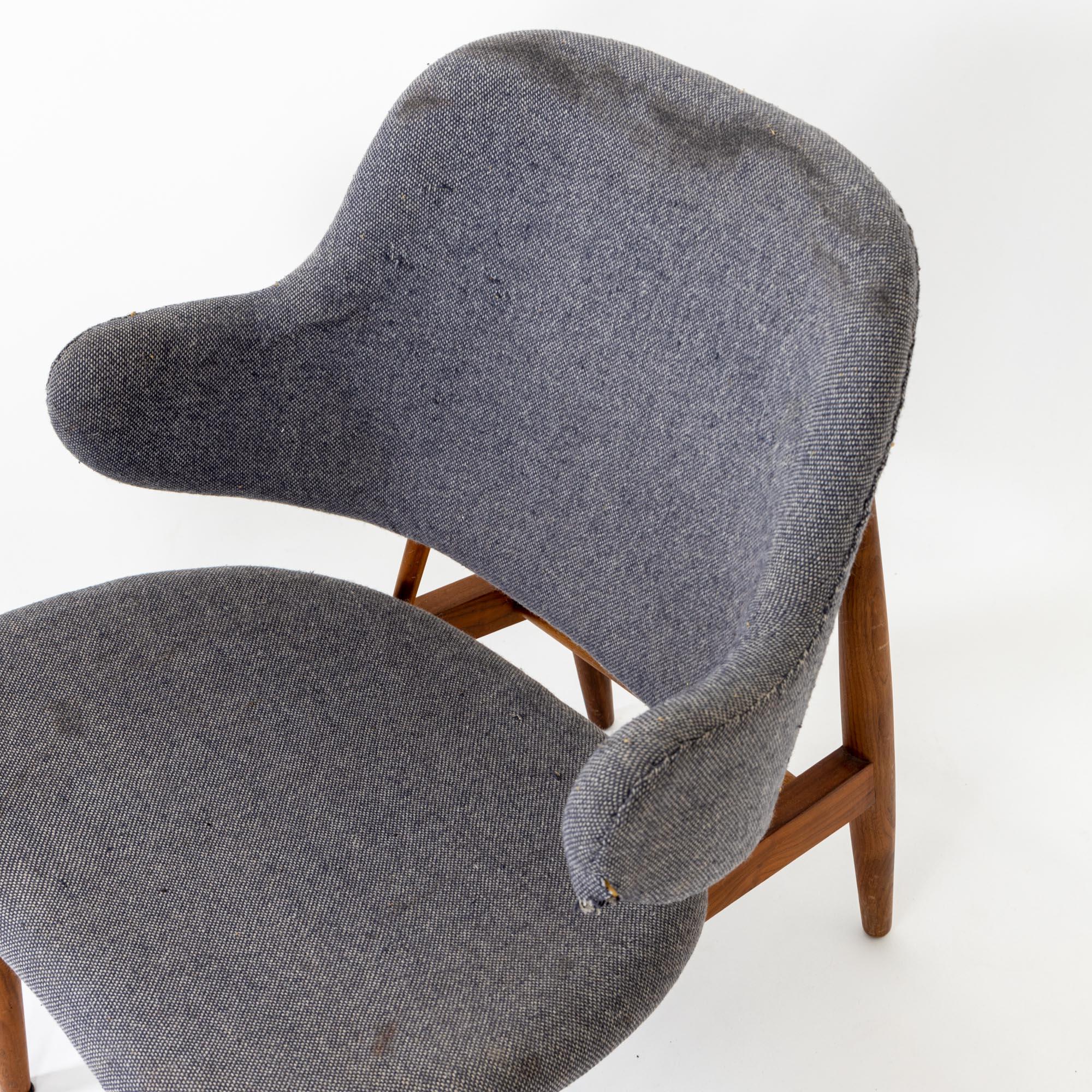 Gray midcentury armchair designed by Danish designer Ib Kofod Larsen in the 1950s. The armchair stands on a dark brown smooth wooden frame and is covered with a gray fabric. The armchair needs to be reupholstered and the wooden frame shows signs of