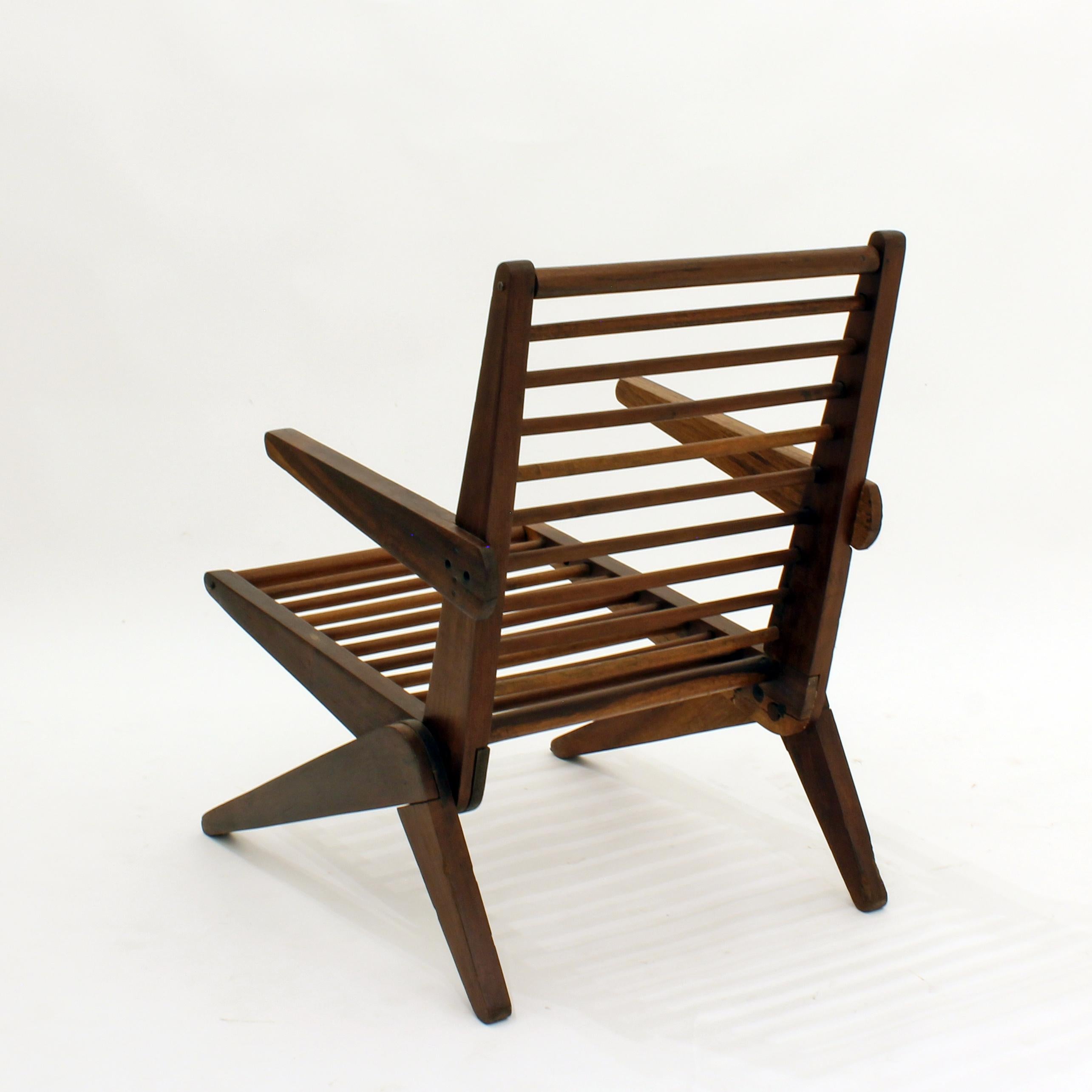 Armchair by Lina Bo Bardi in beautiful original vintage condition. With legs reminiscent of Pierre Jeanneret Knoll Scissor Chairs, however the support backing features round horizontal wood crossbars throughout. As seen in the 2014 exhibition by the