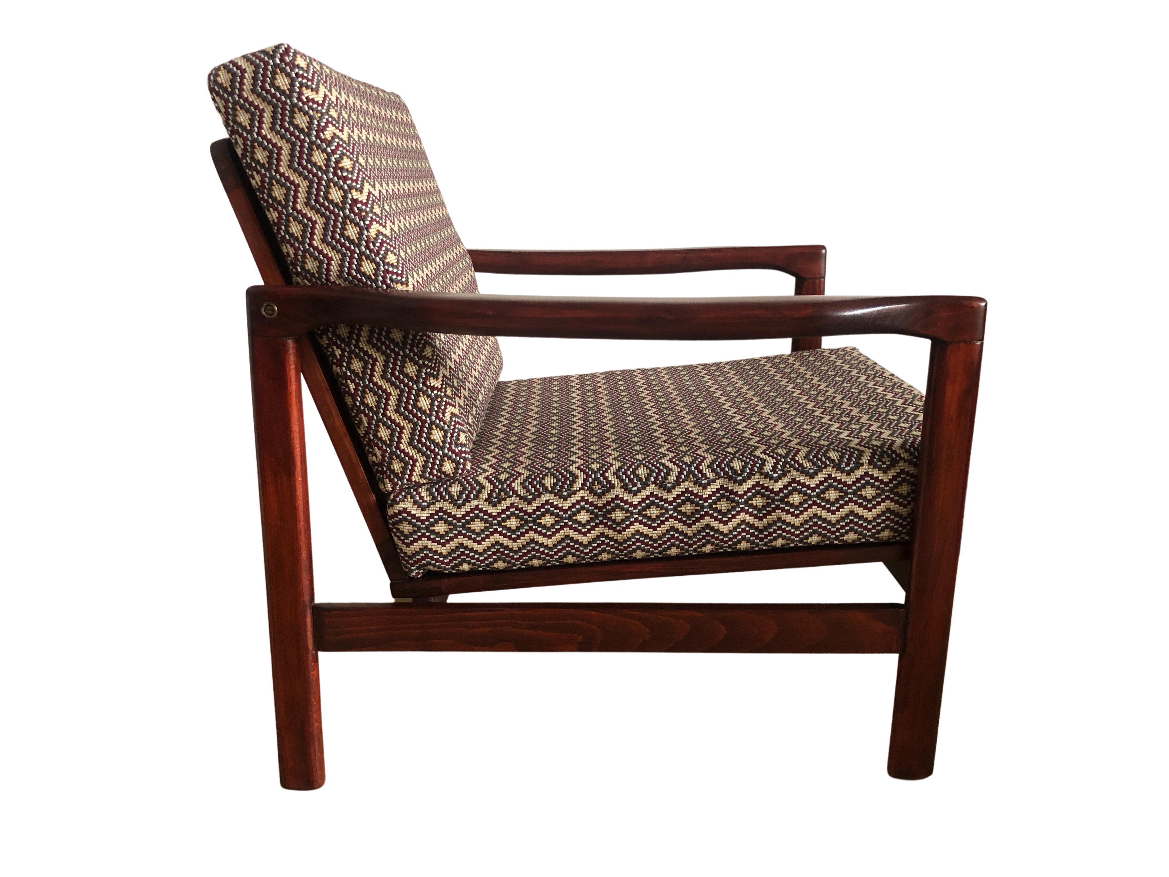 The lounge chair model B-7752, designed by Zenon Baczyk, has been manufactured by Swarzedzkie Fabryki Mebli in Poland in the 1960s. 

The structure is made of beech wood in deep brown color, finished with a semi matte varnish. 

The upholstery