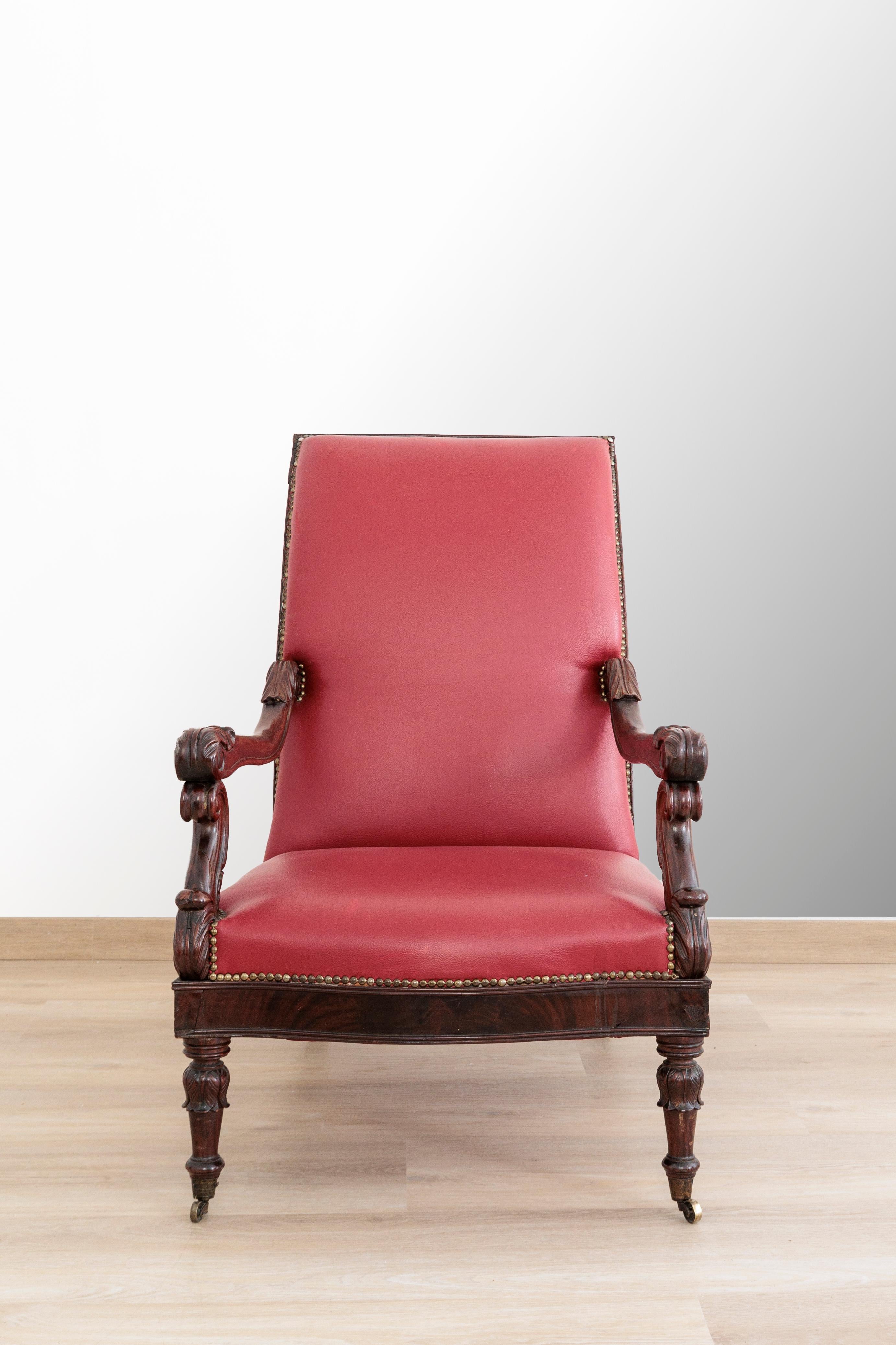 Carlo X lounge chair in mohogany and mahogany feather Beautiful and comfortable, upholstered in red leather. France 1840s. Original. The armchair has wheels in the front legs to facilitate movement. It has carved armrests, flared rear legs that