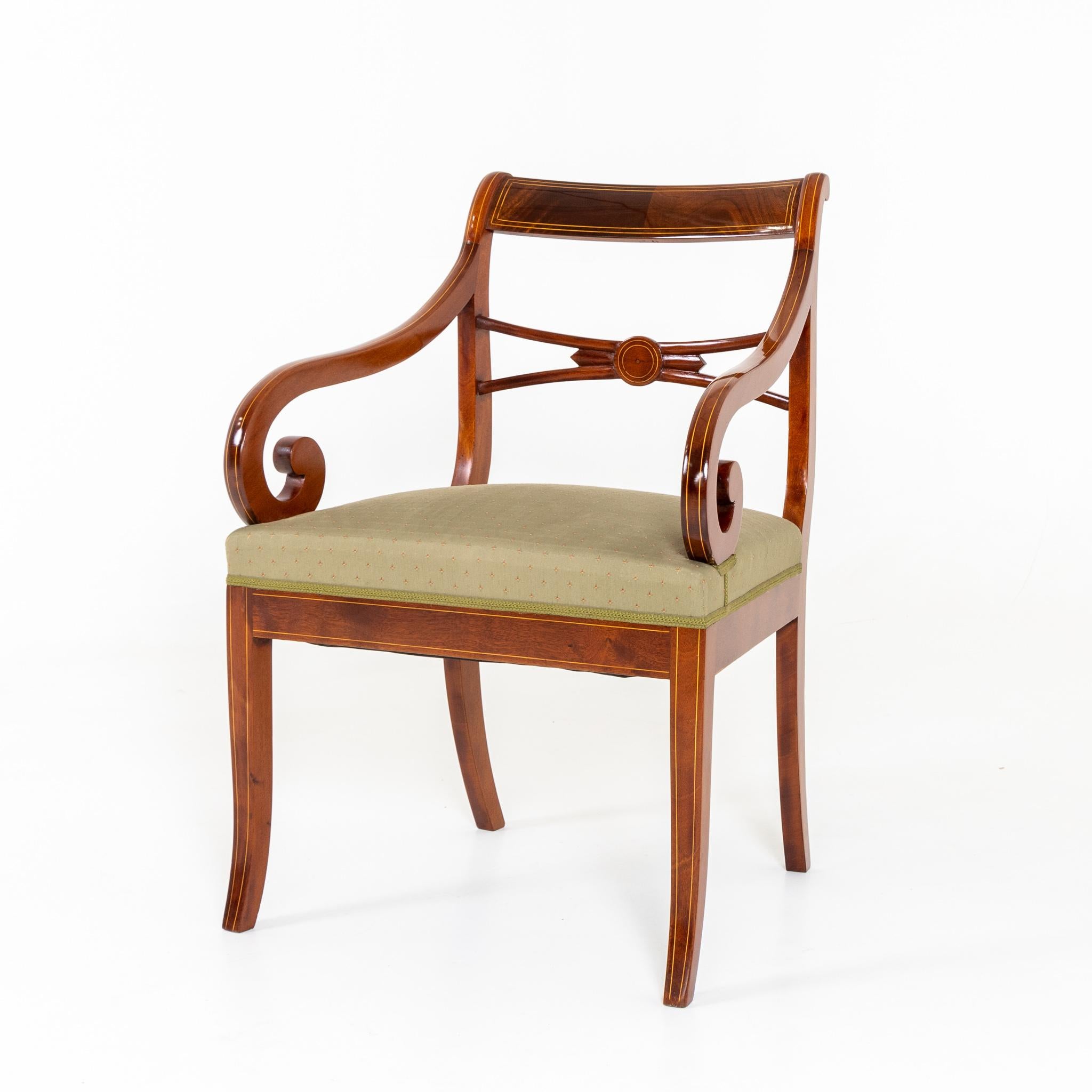 Mahagoni-Sessel mit feinen Fadeneinlagen und volutenförmigen Armlehnen, handpoliert.