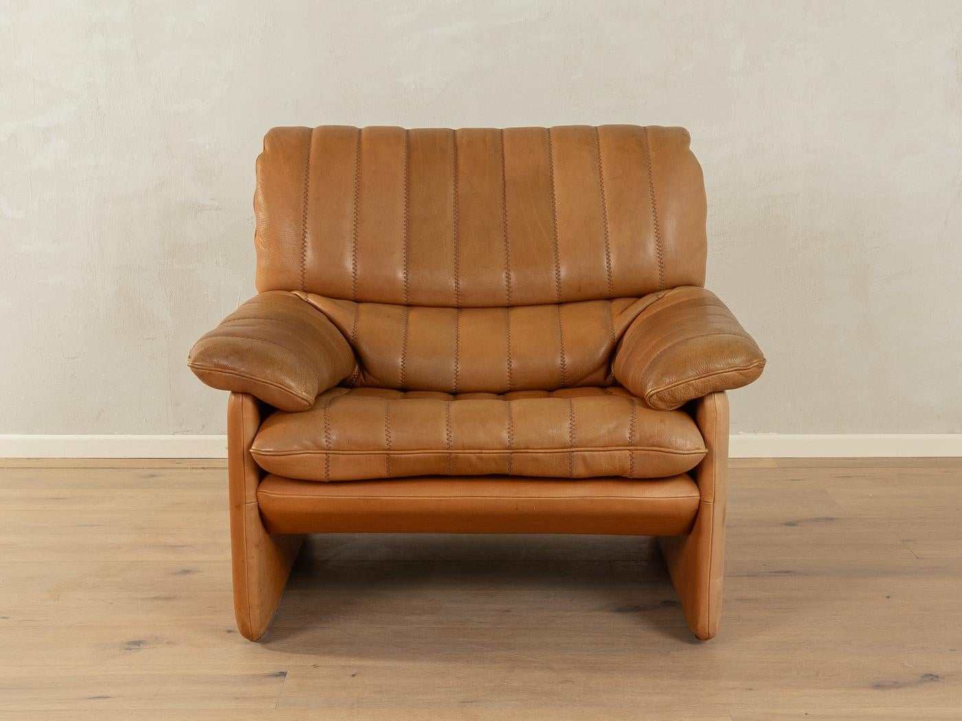 Classic armchair from the 1970s. Model DS-86 by de Sede with the striking original cover made of cognac-coloured leather with a beautiful patina and coarse stitching.

Quality Features:
    very good workmanship
    high-quality materials
    Made