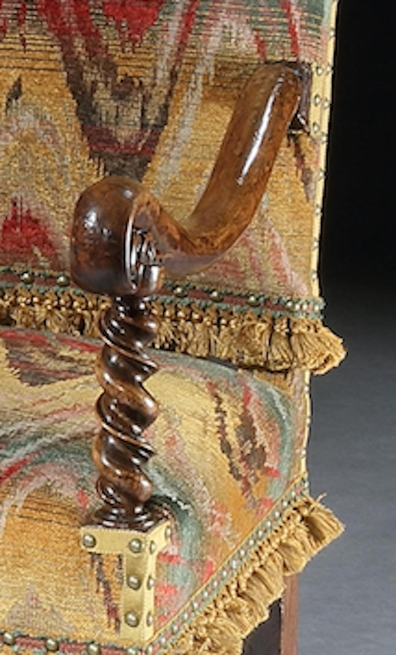 This open armchair is characteristic of the Haute Époque employing elegant barley-twist turnings and sweeping, curved, scroll arms. The bargello is a re-creation of a fashionable upholstery textile of the time and the passmenterie has been custom