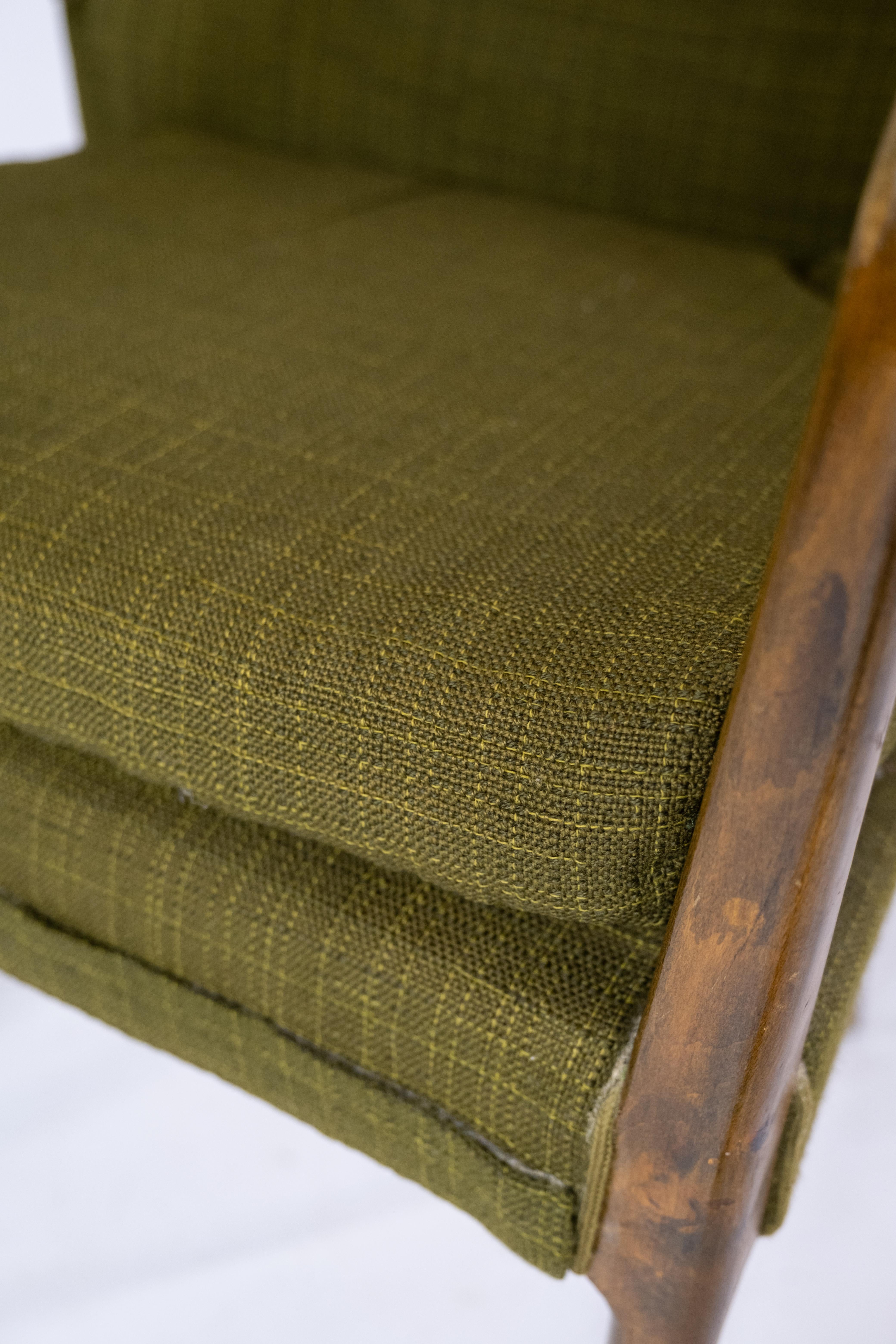 Ce fauteuil, fabriqué en bouleau et revêtu de son tissu vert foncé d'origine, incarne l'élégance intemporelle et le savoir-faire exceptionnel du design danois des années 1950.

L'utilisation du bois de bouleau ajoute non seulement une touche de
