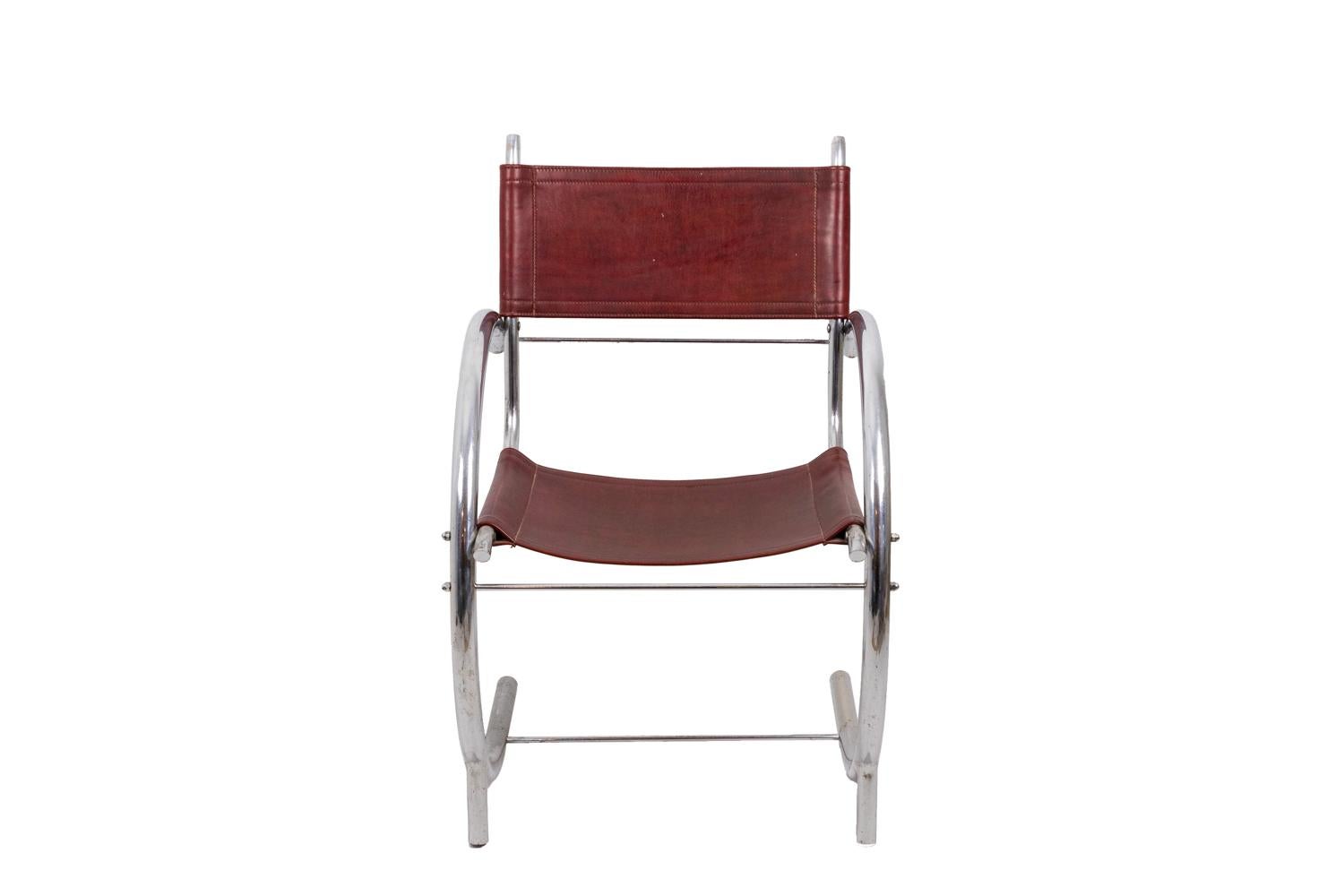 Poltrona in metallo cromato con gambe e braccioli che formano un semicerchio. Le gambe sono collegate tra loro da una barella a bastone. Seduta e schienale in pelle rossa di forma rettangolare.

Opera realizzata negli anni '30.