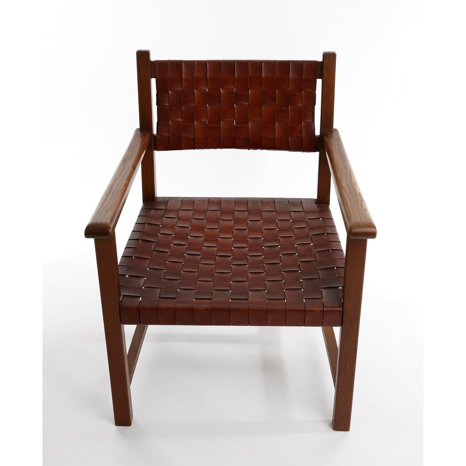 Ein wunderbarer Mid-Century Modern Sessel aus massiver Eiche, hergestellt in Europa in den 1960er Jahren.
Schöne Maserung des Eichenholzes und dicke geflochtene oder gewebte patinierte Lederriemen an Rückenlehne und Sitz in warmem cognacbraunem