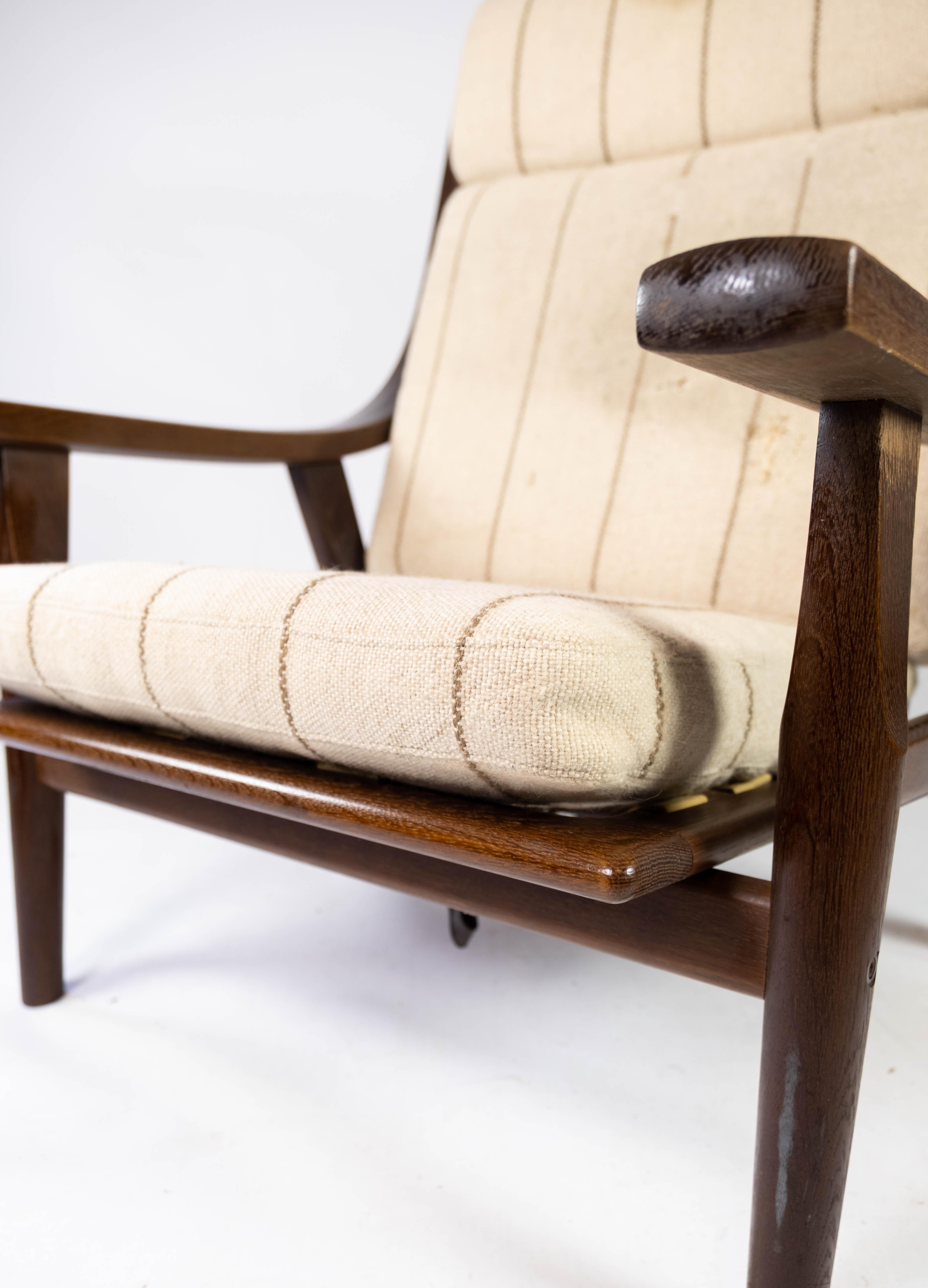 Der mit hellem Stoff bezogene Sessel aus dunkler Eiche mit der Modellnummer GE530 ist ein großartiges Beispiel für Hans J. Wegners einzigartigen Beitrag zum dänischen Möbeldesign der 1960er Jahre. Der Stuhl strahlt eine zeitlose Eleganz und