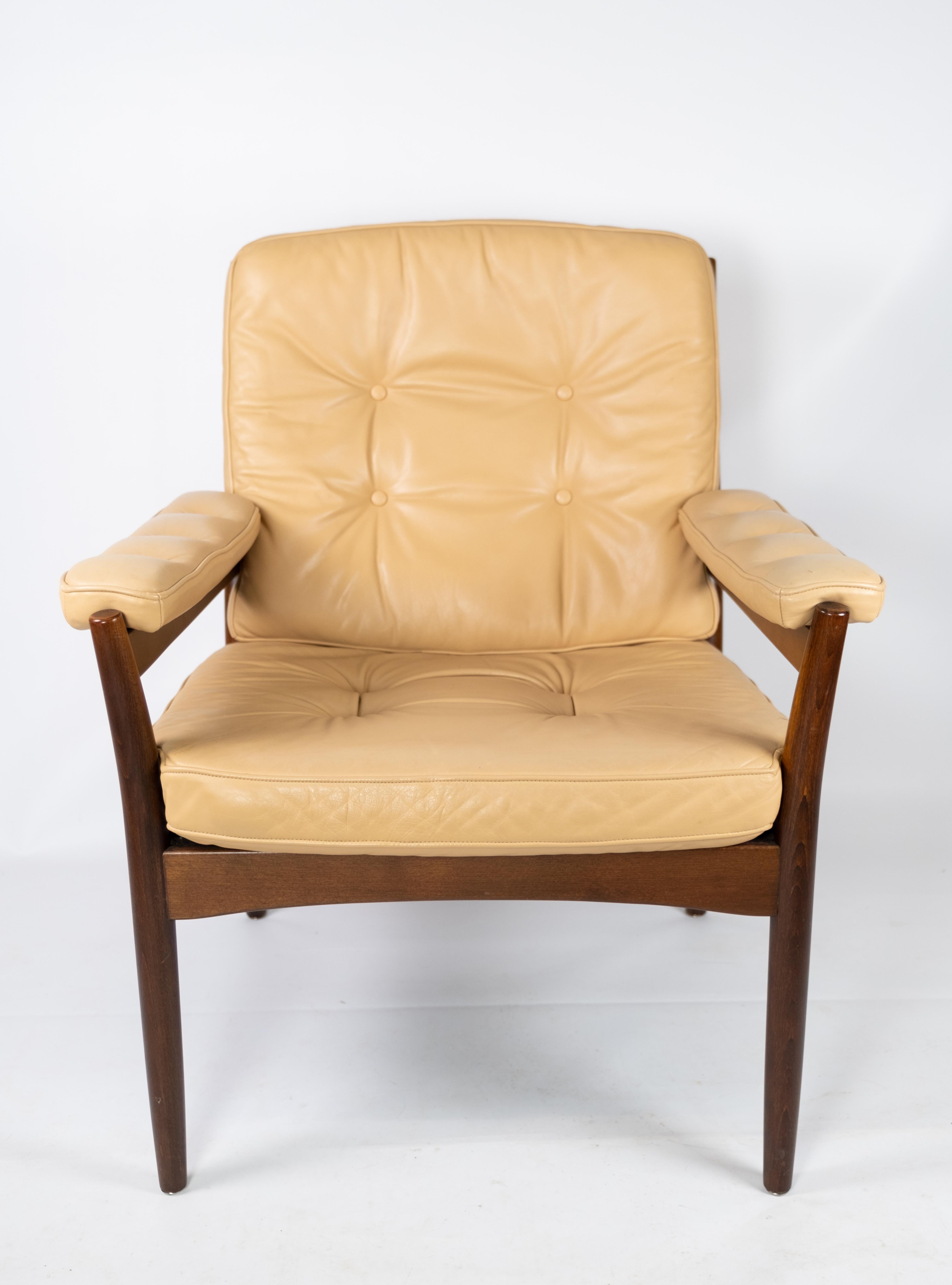 Armchair in dark wood and upholstered with light elegance leather of Danish design from the 1960s.The chair is in great vintage condition.