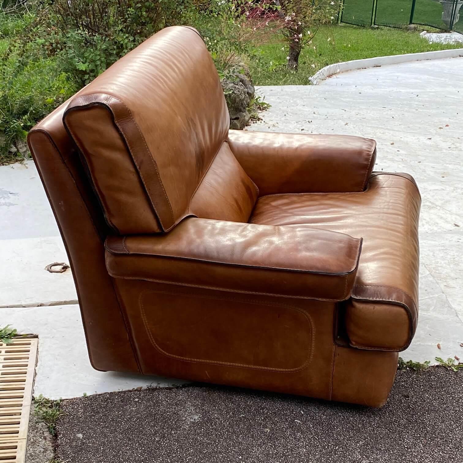 With its stitched scellier seam, this armchair inspire vintage quality. Brown leather with some marks, with its beautiful patina.