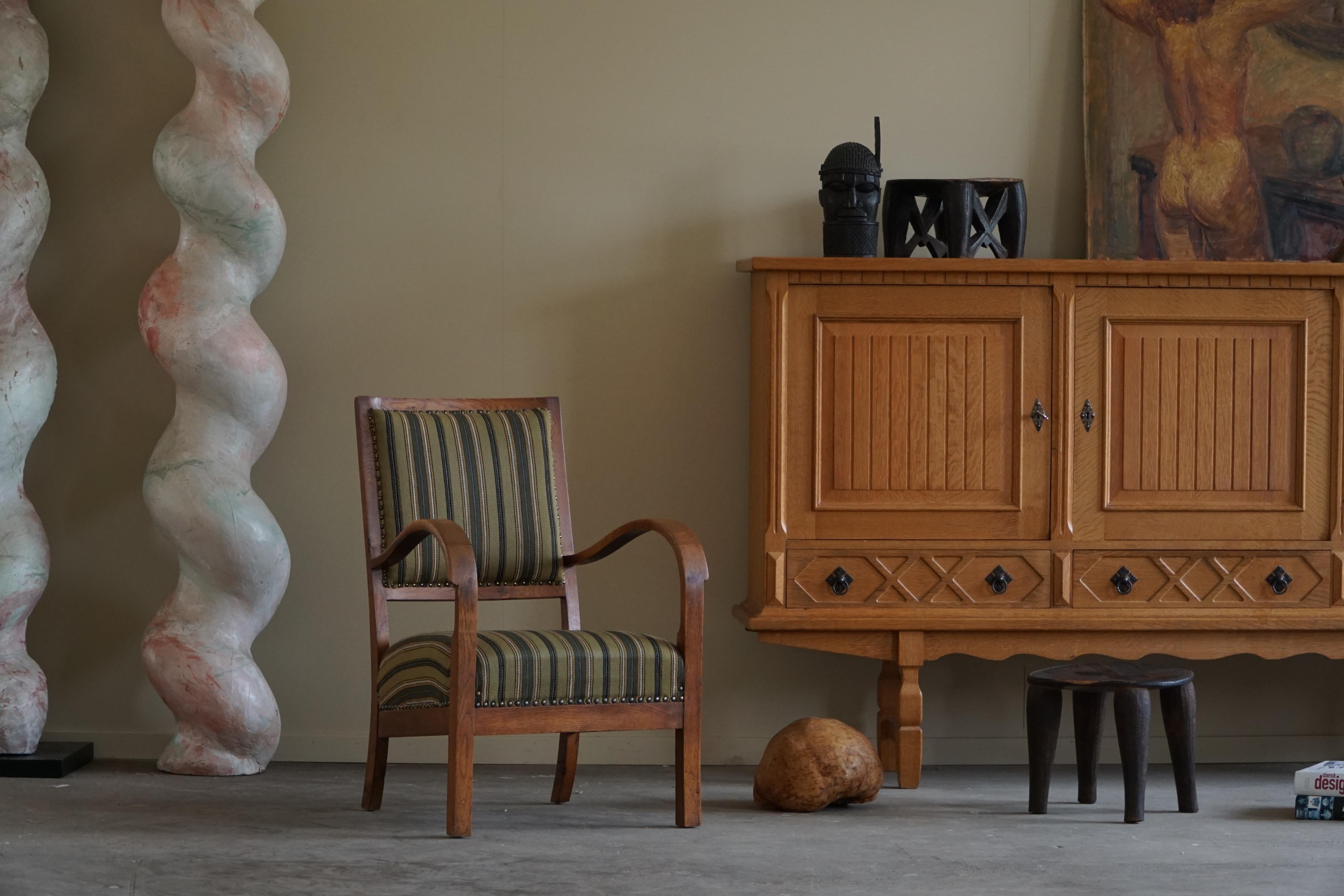 Ein fabelhafter Sessel aus massiver Eiche und Stoff. Gefertigt von einem erfahrenen dänischen Tischler, mit einer Kombination aus hochwertigem Eichenholz und weichen, bequemen Stoffbezügen. Hergestellt in den 1950er Jahren.

Dieser Stuhl zeichnet
