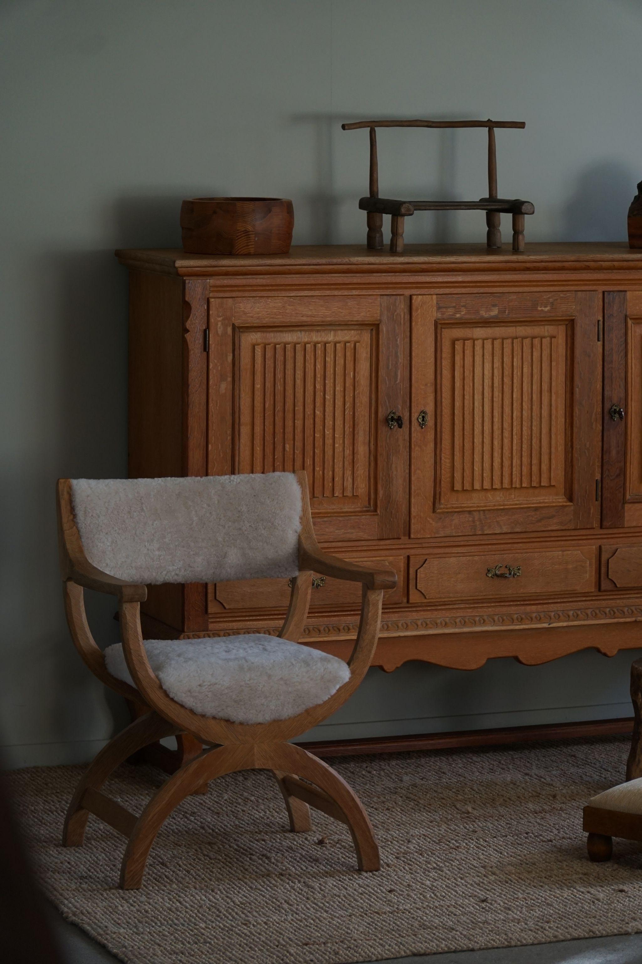 A fine and elegant armchair in solid oak, reupholstered in quality shearling lambswool. Designed by Henning (Henry) Kjaernulf for EG Kvalitetsmøbel, Denmark 1960s. Model 