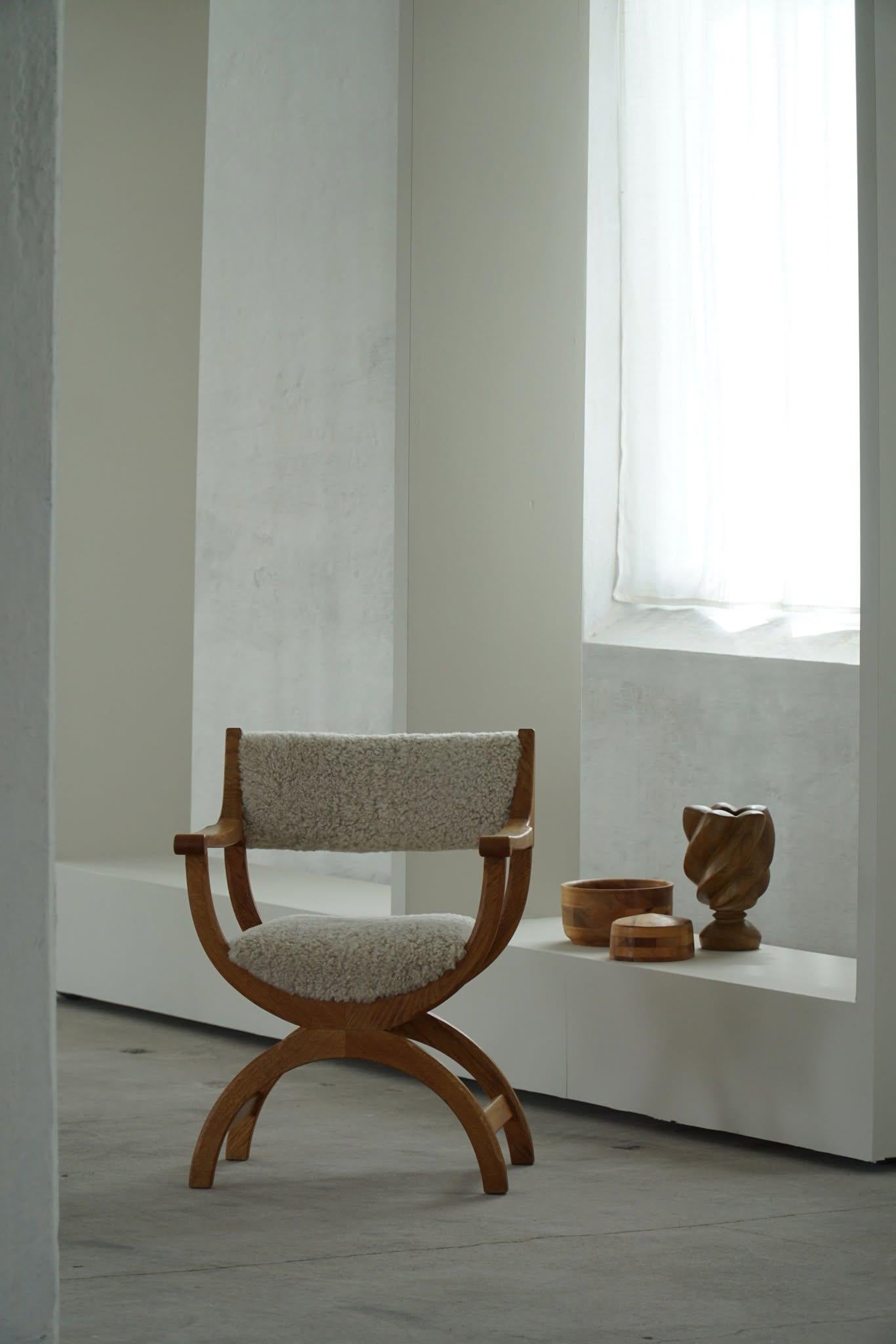 A fine and elegant armchair in solid oak, reupholstered in quality shearling lambswool. Designed by Henning (Henry) Kjaernulf for EG Kvalitetsmøbel, Denmark 1960s. Model 
