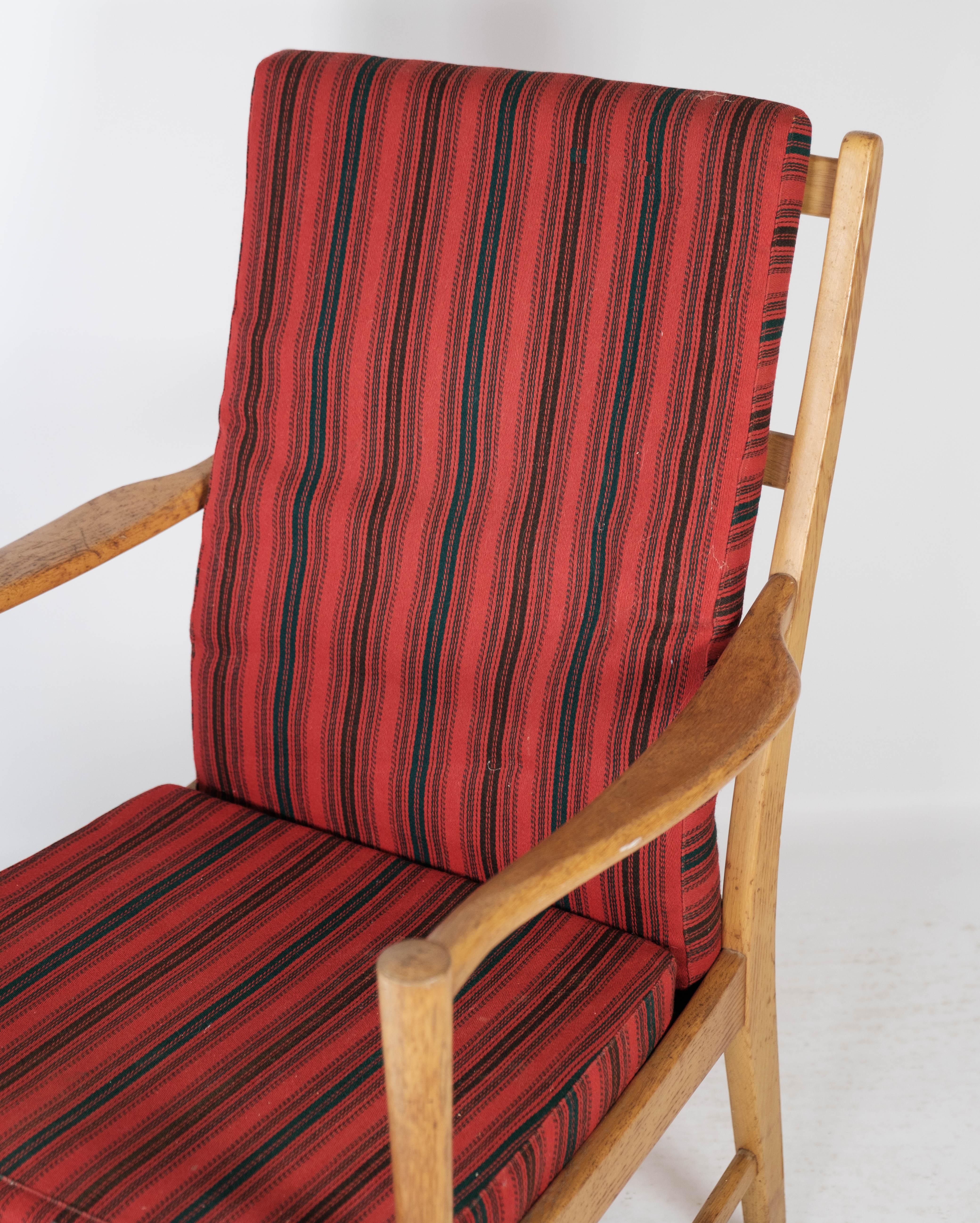 Armchair in oak and with cushions upholstered with red striped fabric, of Swedish design manufactured by Bjärnums Furniture in the 1960s. The chair is in great vintage condition.
  