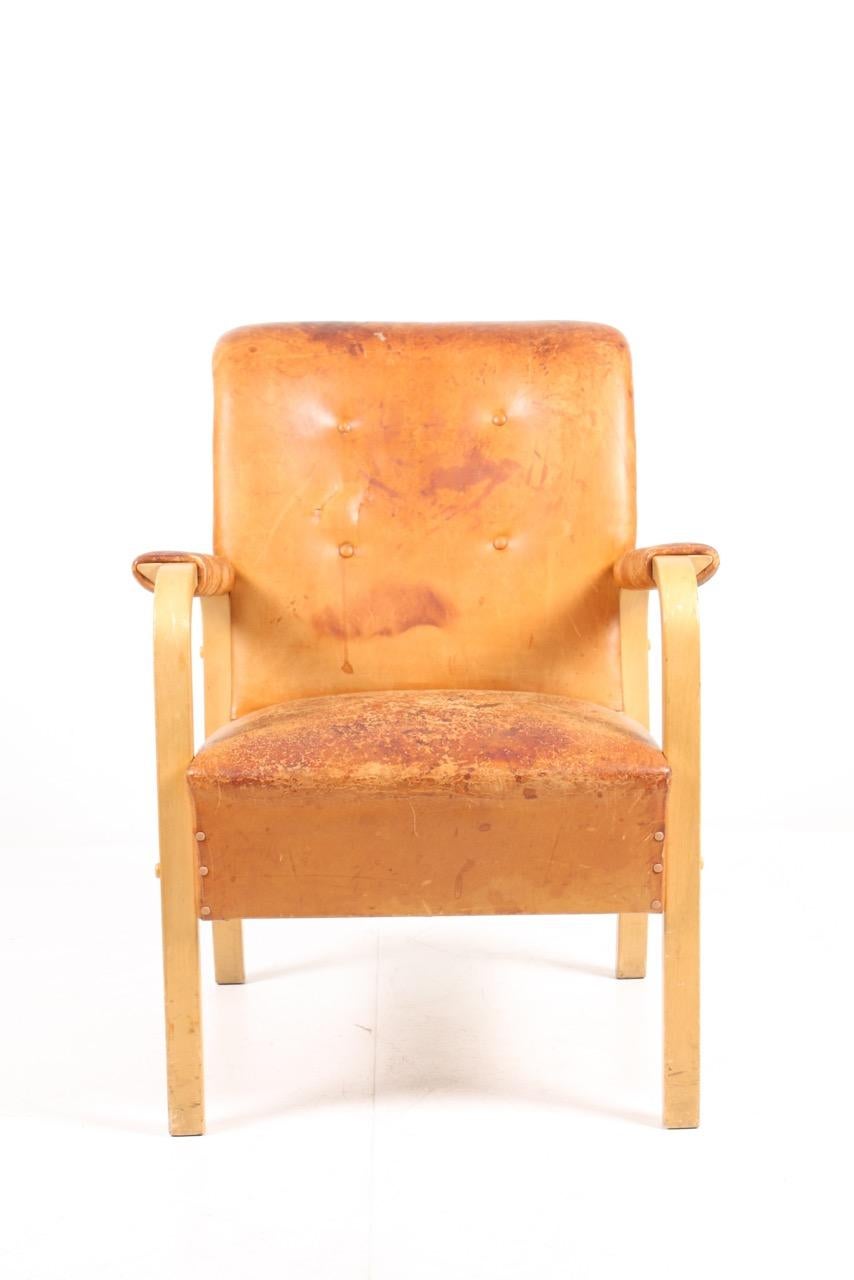 Armchair in patinated leather. Designed by Alvar Aalto in 1947 for Artek. Original condition.