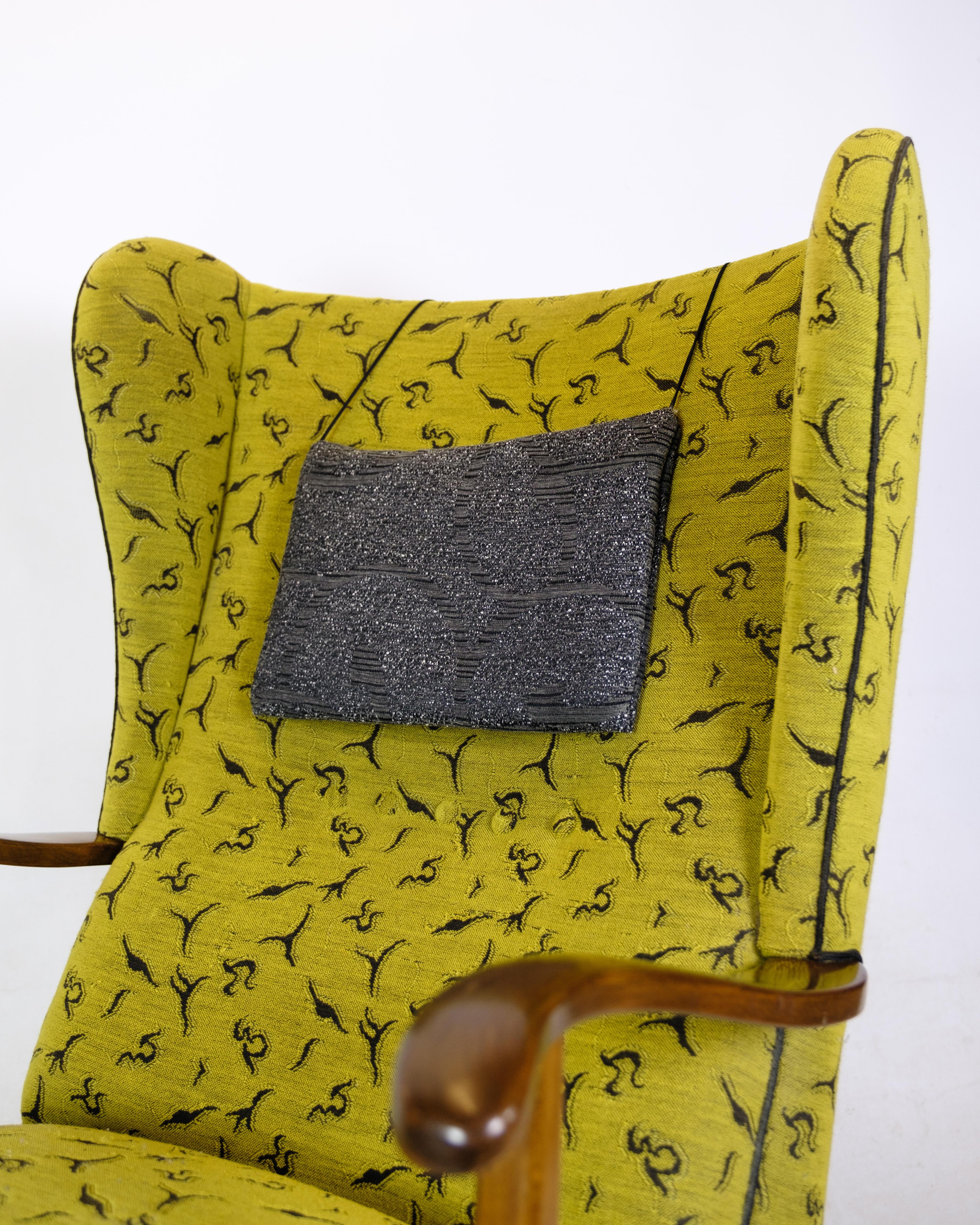 Armchair by a Danish master carpenter in dark polished wood upholstered in gray and yellow patterned fabric from around the 1940s.
Measurements in cm: H:103 W:65 D:85/52 SH:41