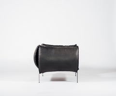 Sillón de cuero negro liso y acero cortado a láser
