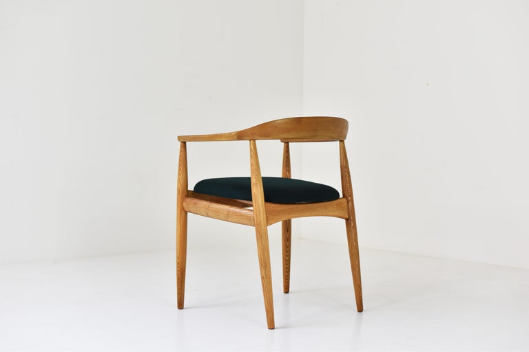 Armchair in solid oak designed by Illum Wikkelsø for Niels Eilersen, Denmark 1950s. This sculptural chair is professionally re-upholsterd in a high quality forest green fabric upholstery by Raf Simons. The oak wood is restored with love. Clean