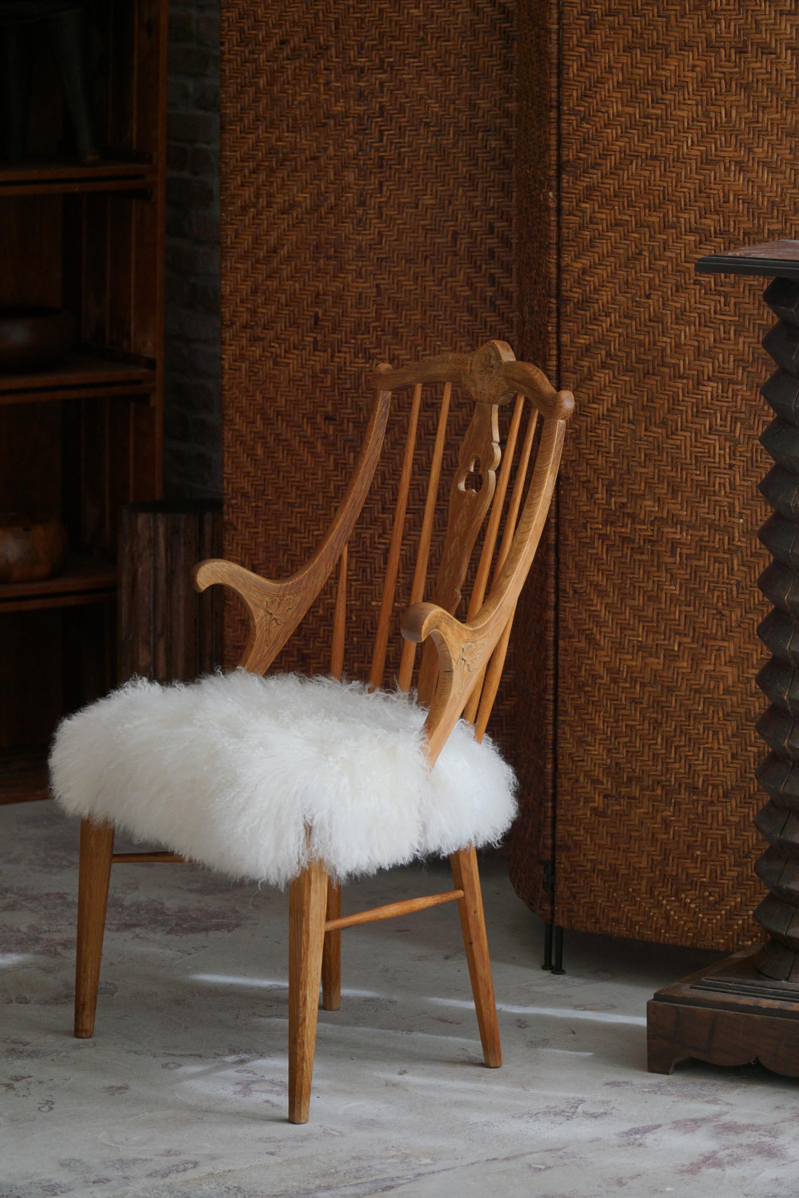 Ein schöner Hochlehner-Sessel aus massivem Eichenholz mit einem mit Lammfell gepolsterten Sitz.
Gefertigt von einem geschickten dänischen Tischler Mitte des 20. Jahrhunderts. Das Gestell des Stuhls ist sorgfältig aus massiver Eiche geschnitzt, einem