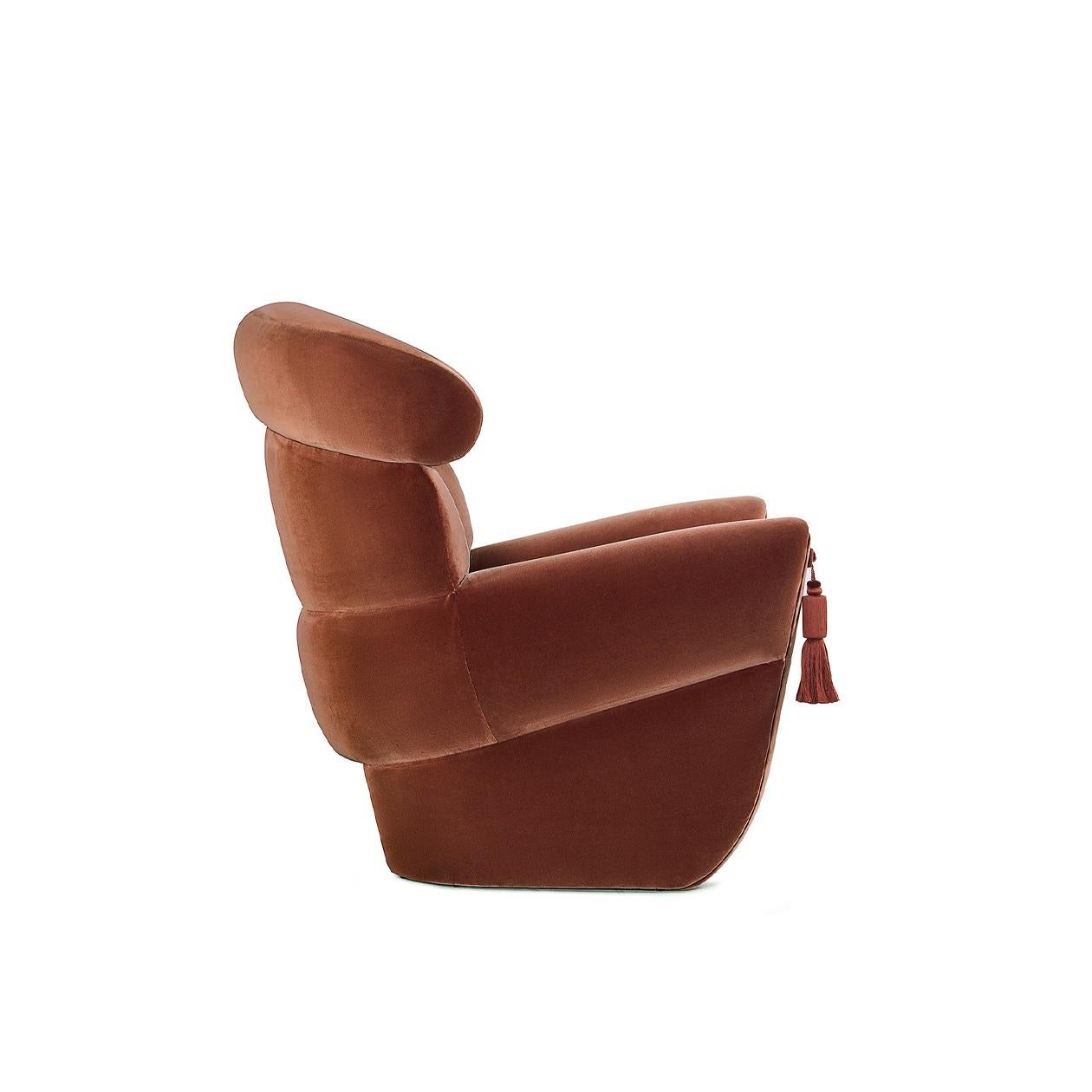 Questa poltrona fonde il glamour della Hollywood d'epoca con la sensibilità del design moderno. Le sue curve aggraziate e l'imbottitura meticolosamente confezionata trasudano raffinatezza classica, mentre gli accenti di nappe sui braccioli