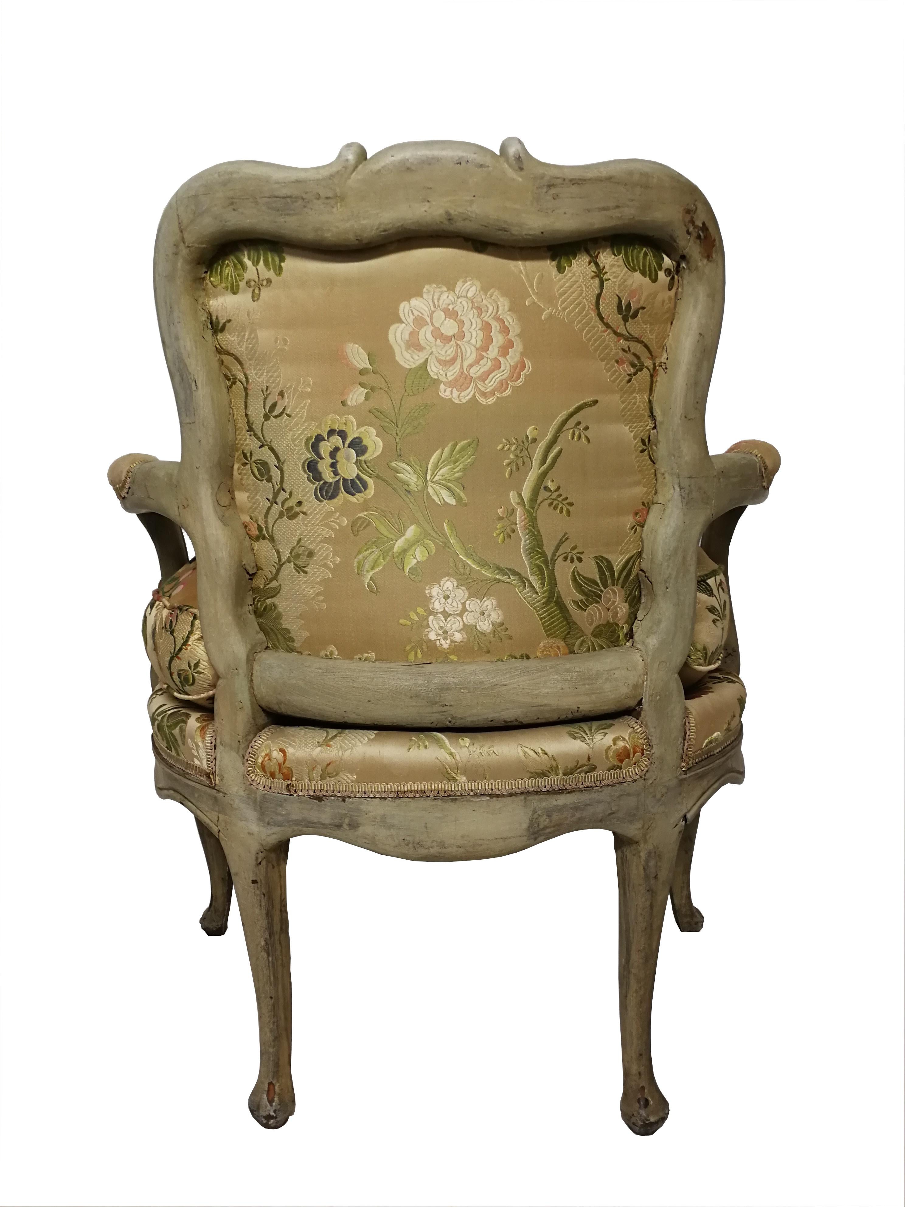 Petit fauteuil Louis XV d’époque
Small low Louis XV armchair of the 18th century. It keeps its original grey paint and it was re-upholstered in the 60's with silk handwoven fabric with floral motifs in green, pink and blue tones over cream