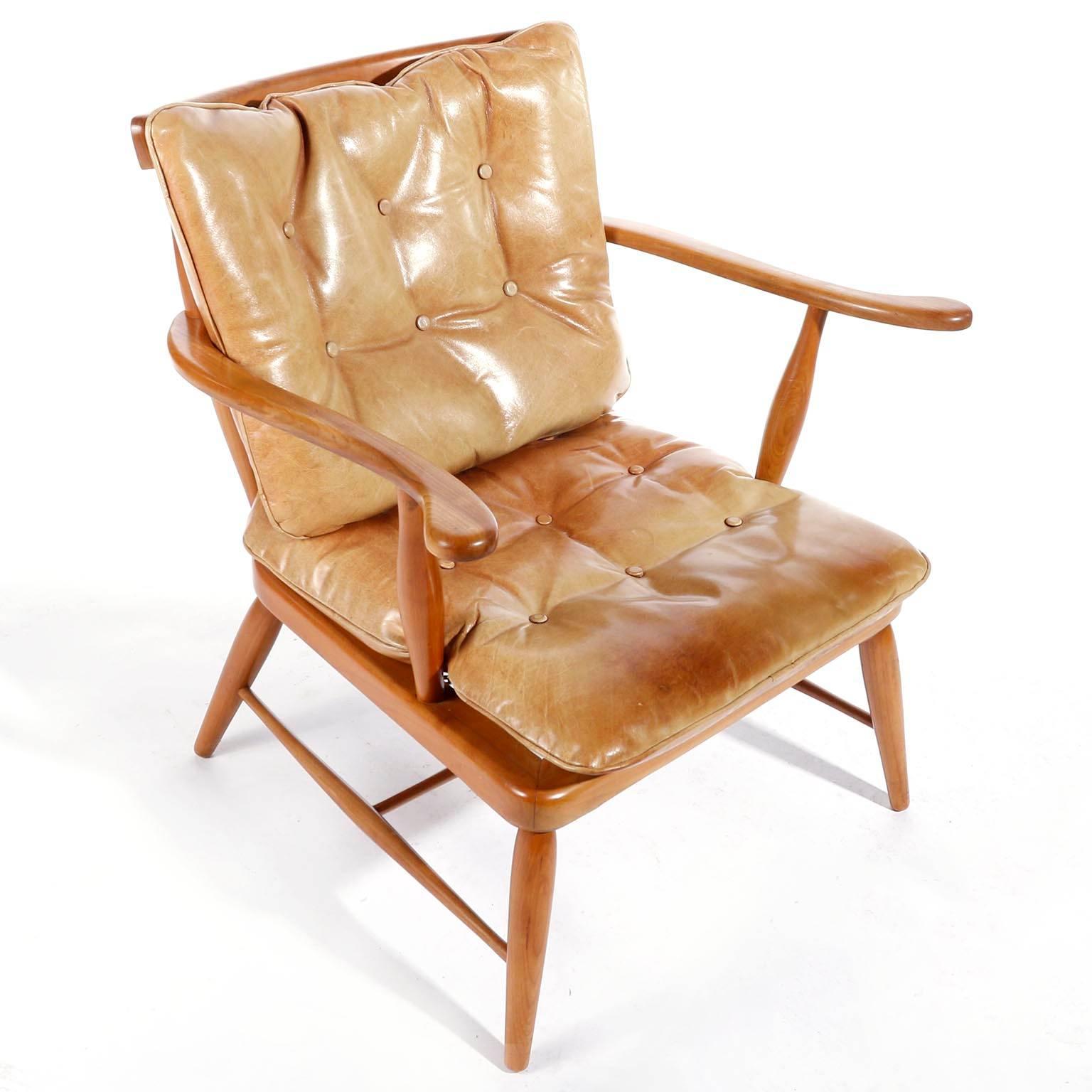 A spindle back armchair designed by Anna-Luelja Praun (1906-2004), Vienna, Austria, manufactured in midcentury, circa 1952.
It is made of a warm toned solid wood frame with two loose leather cushions for the seat and the back. The cognac colored