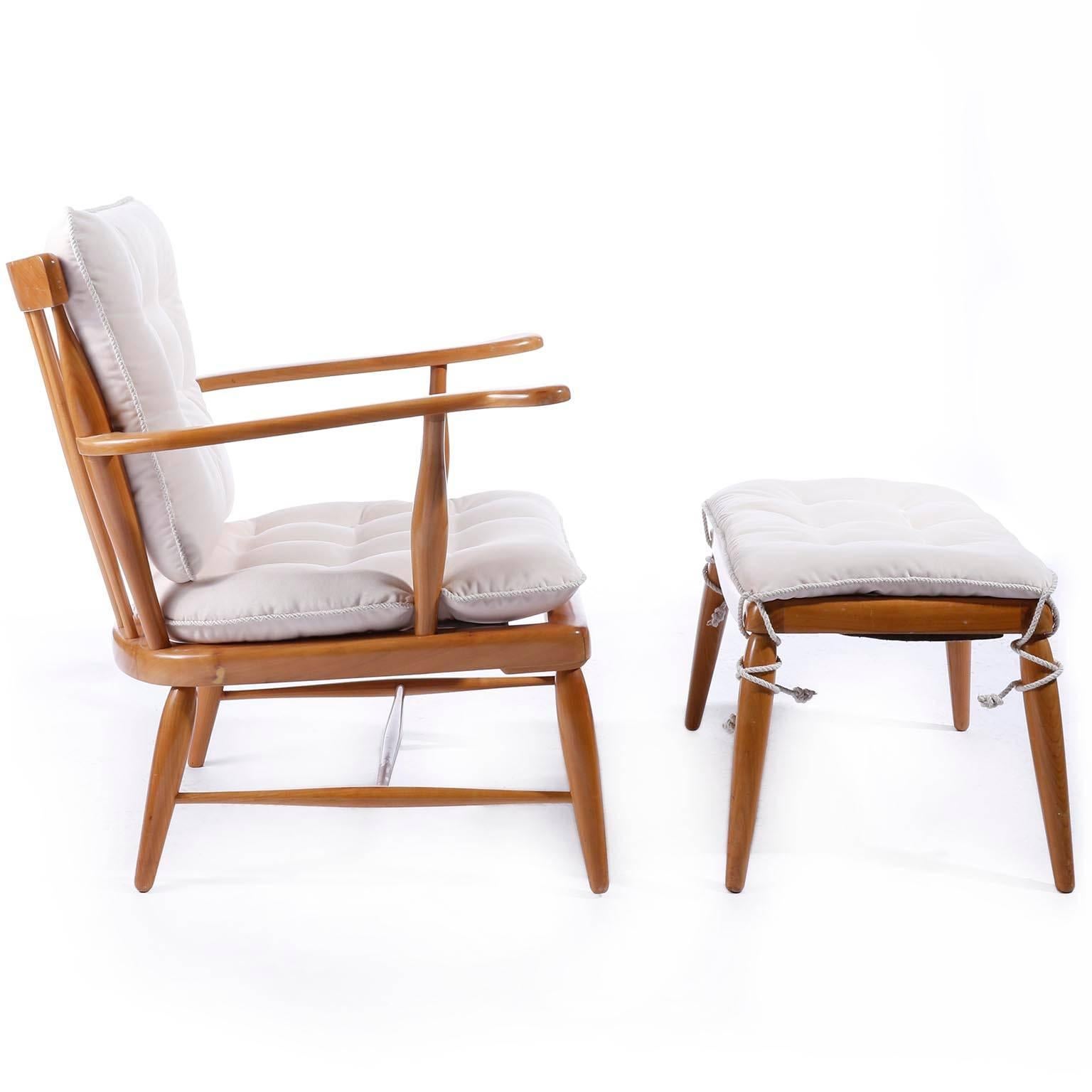 An easy chair with ottoman designed by Anna-Luelja Praun (1906-2004), Vienna, Austria, manufactured in midcentury, circa 1952.
It is made of a warm toned solid wood frame with loose cushions for the seats and the back. 
The cushions have been