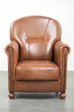 Armchair made of sheepskin leather with refined decorative nail finish