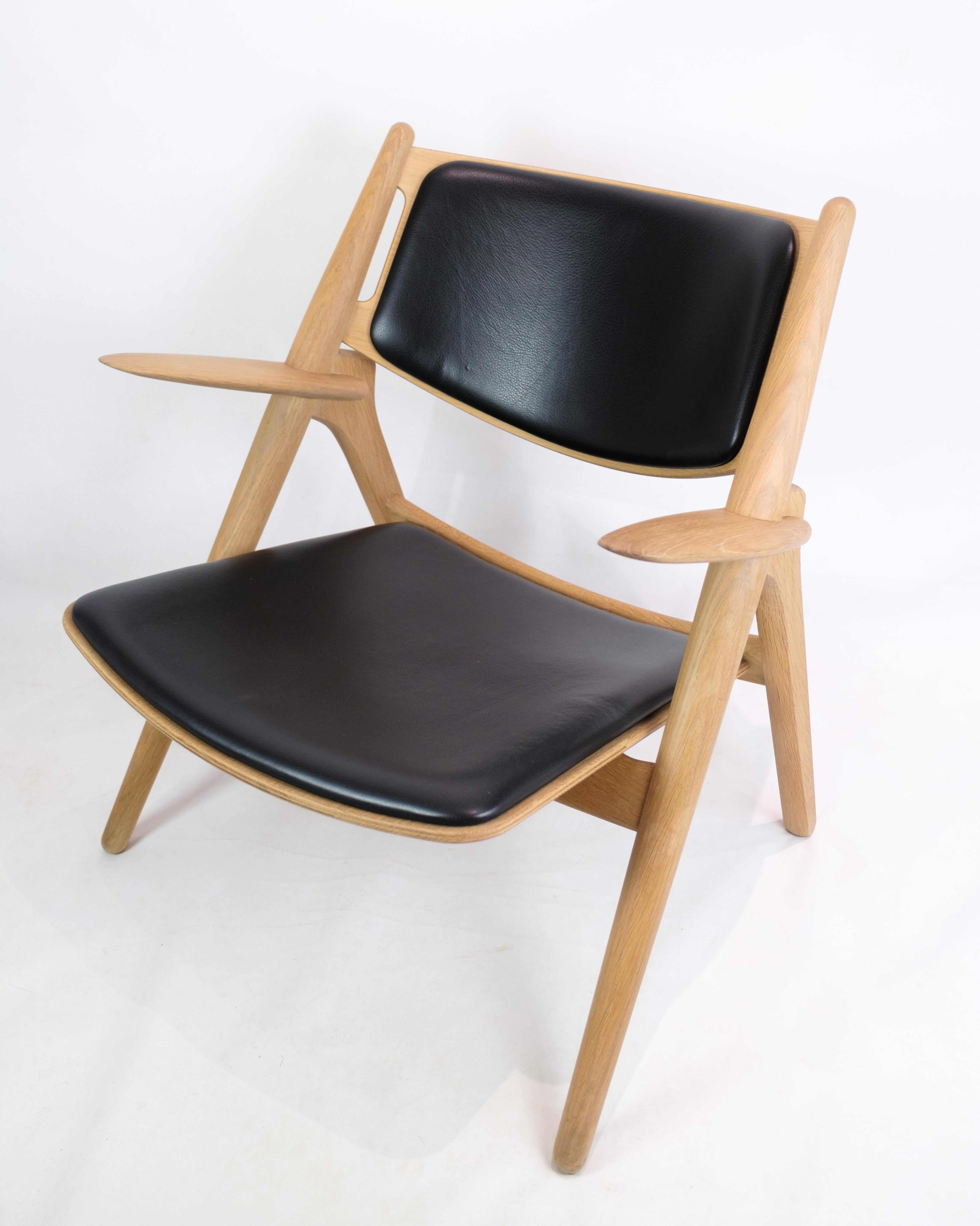 Der Sessel, Modell CH28, stellt eine sublime Begegnung zwischen Funktionalität und Ästhetik dar. Er wurde von dem bekannten Designer Hans J. Wegner entworfen und von Carl Hansen & Søn hergestellt. Diese aus massivem Eichenholz gefertigte