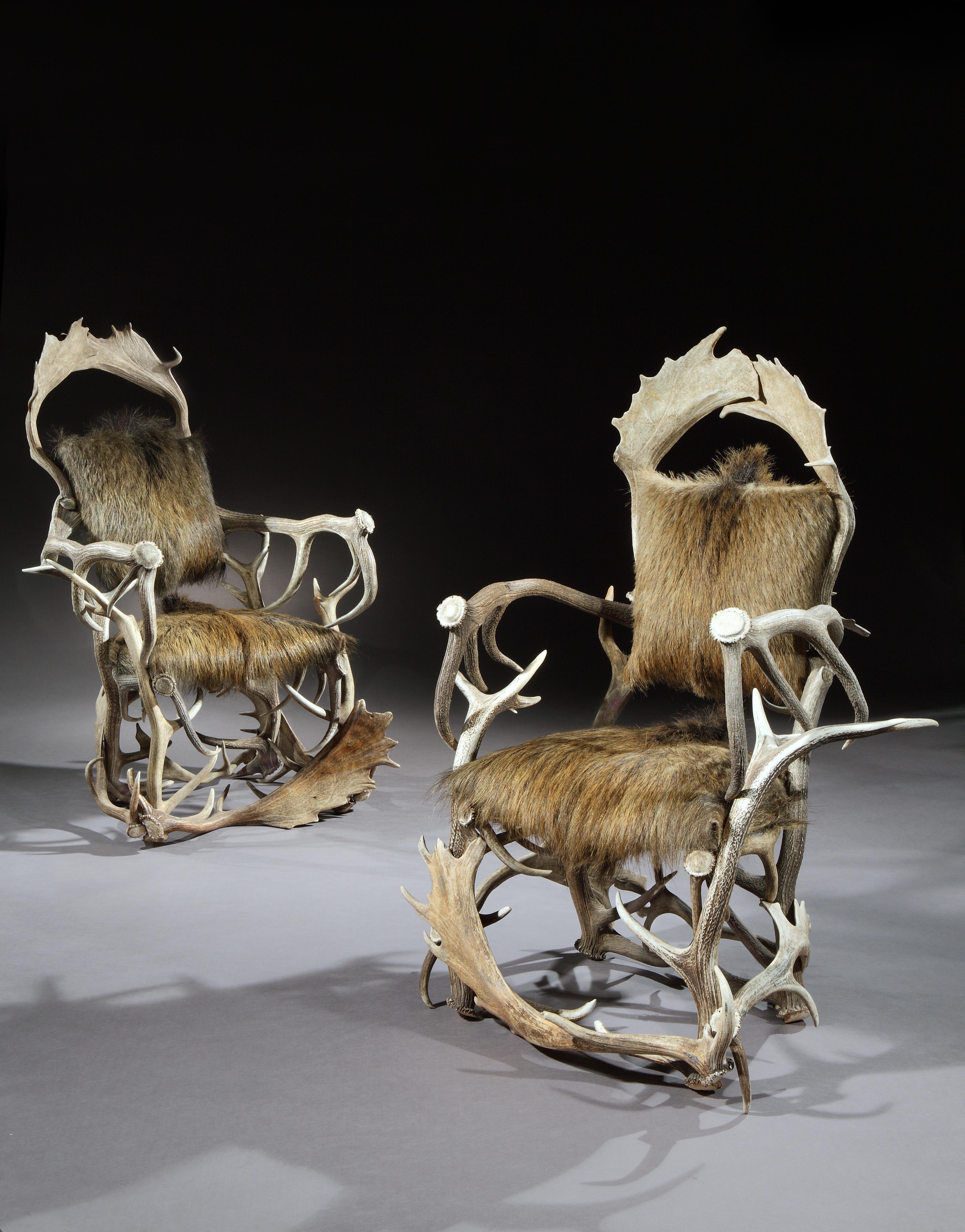 Pairs of hunting trophy armchairs are exceptionally rare. This pair are also unusual because they are made from a few large antlers giving them a minimalist quality. The fluid form of the antlers creates a sculptural, organic aesthetic. They are