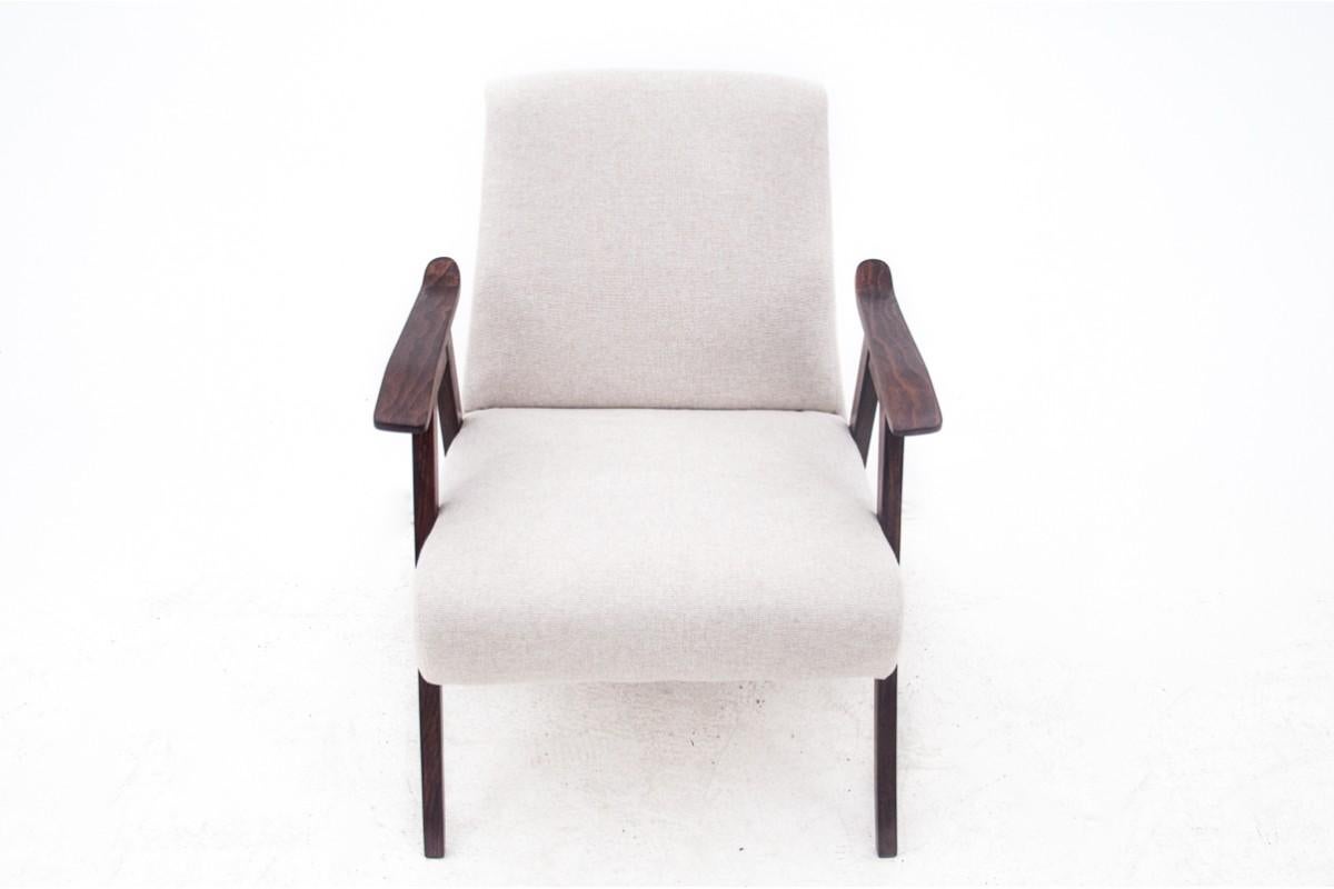 Sillón cómodo y elegante fabricado a mediados del siglo XX. El mueble está tapizado en un agradable tejido, el conjunto descansa sobre patas rectas, apoyabrazos de interesante perfil. Muy buen estado, tras una renovación profesional y sustitución