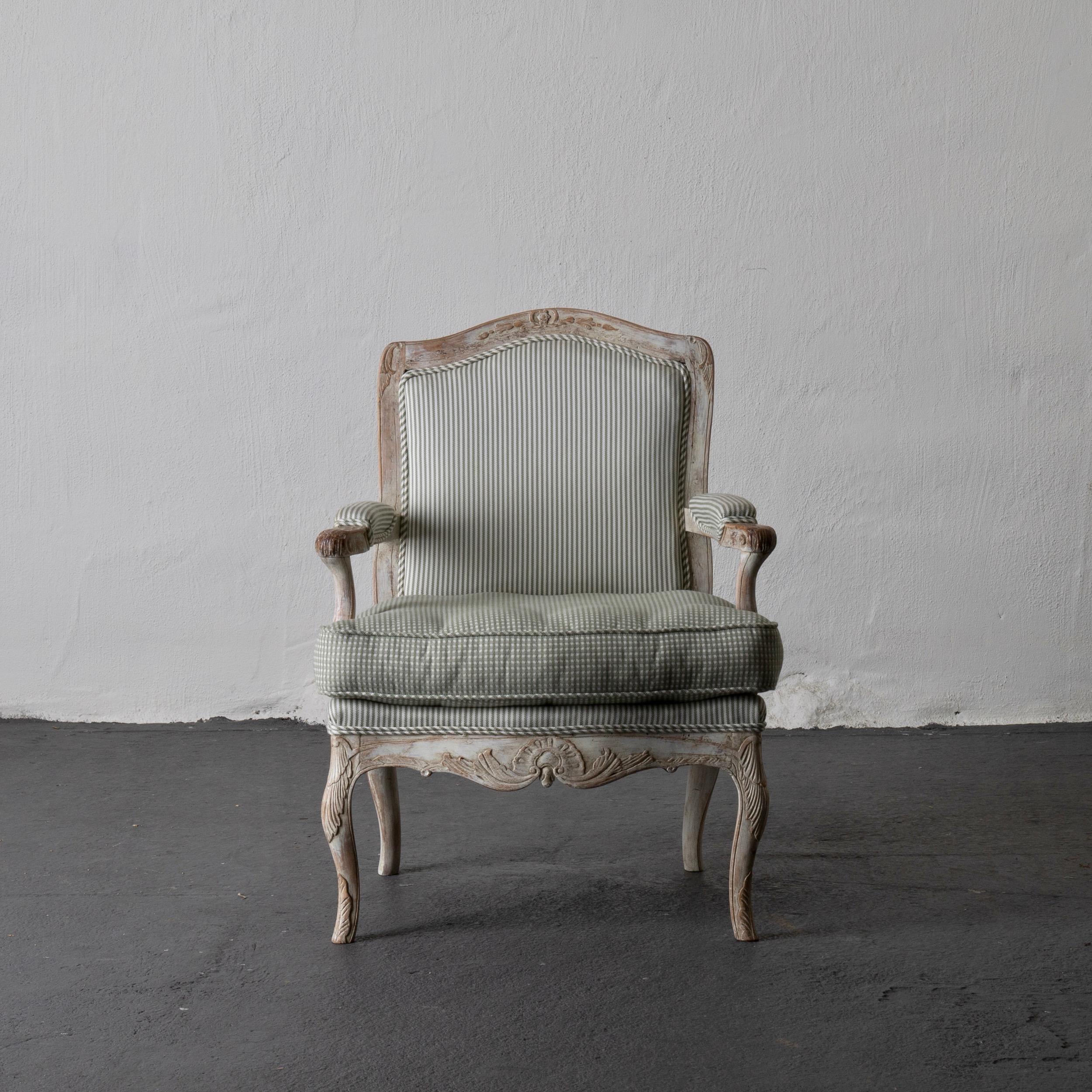 Sessel Rokoko Schwedisch weiß hellgrün, Schweden. Ein einzelner Sessel mit Originallackierung aus der Zeit des Rokoko (1750-1775) in Schweden. Ein weiß gewaschener Holzrahmen, verziert mit Rocailles und Akanthusblättern. Retuschierte Farbe.

 