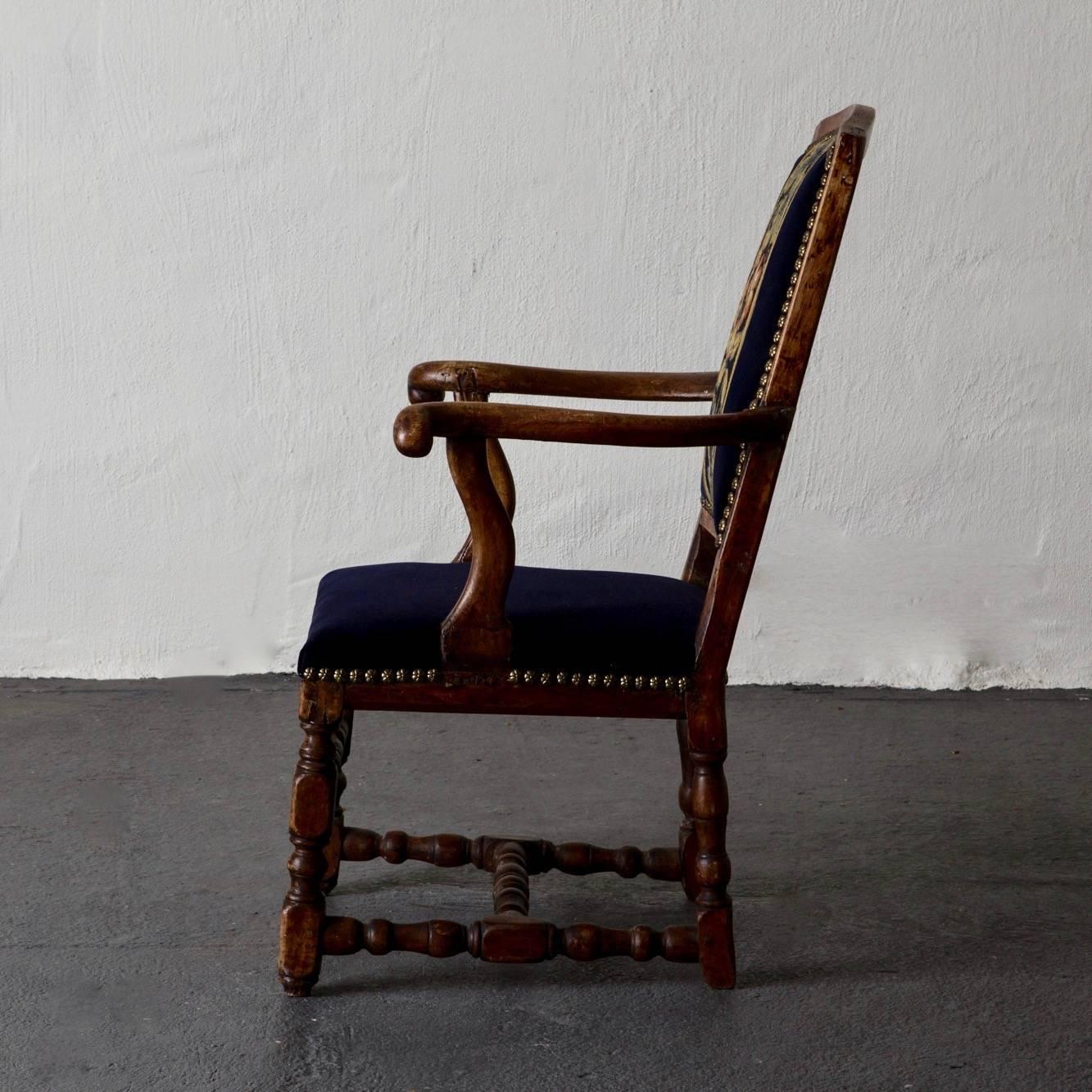 Armchair Swedish Baroque oak, Sweden. A single armchair made in Sweden during the early part of the Baroque period. Frame made of oak with an upholstered back splat and seat in dark blue. Out-curved armrests and turned legs with a foot cross.
 