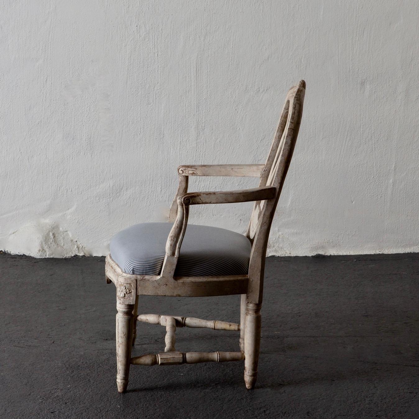 Armchair Swedish Gustavian 1775-1790 white washed, Sweden. An armchair made during the early part of the Gustavian period circa 1775-1790. A rounded open back splat with an urn shaped middle part decorated with a carved rose on top. Curved armrests