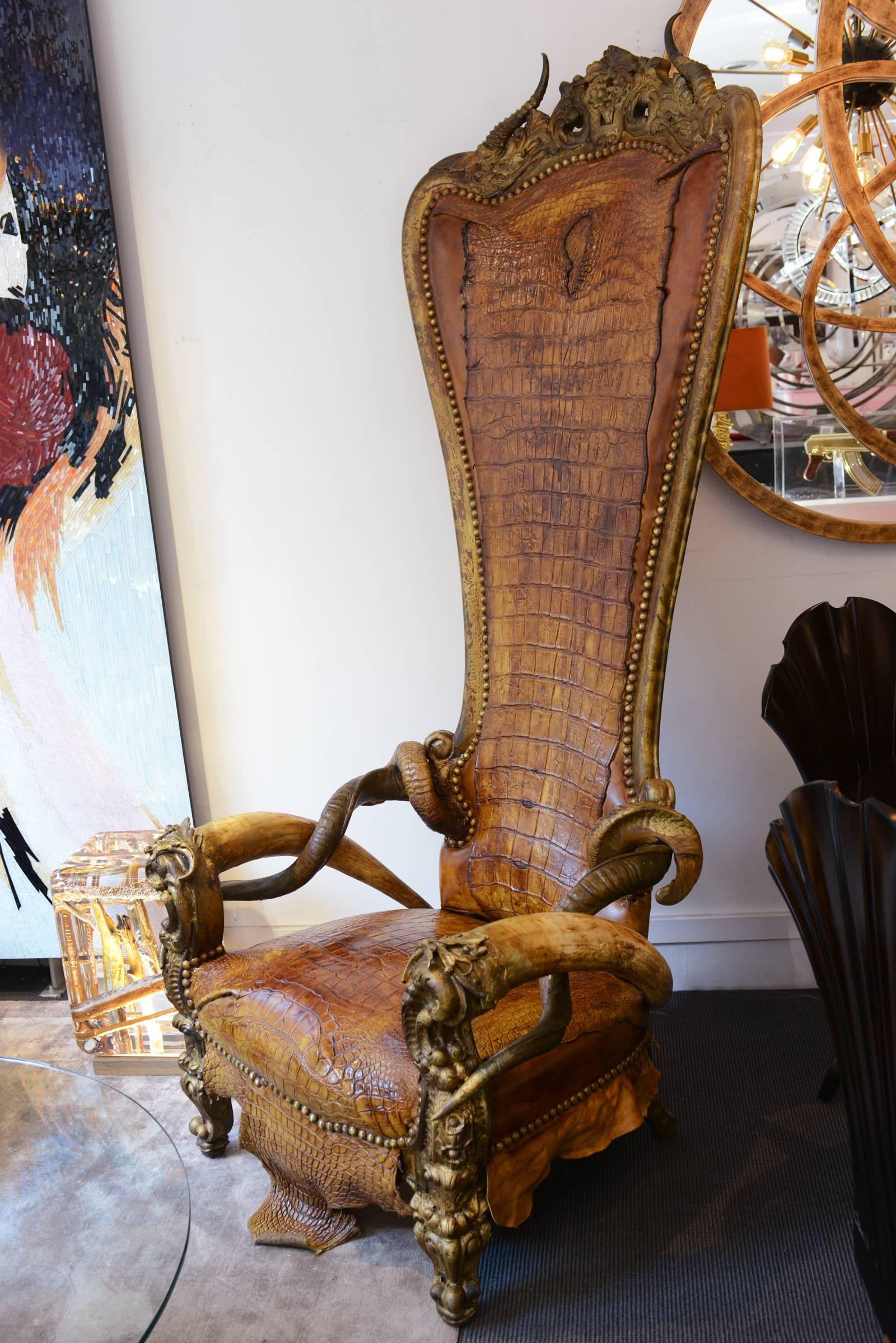 Crocodile master armchair throne with structure in solid
beech wood. Upholstered with real natural Mississipi
Alligator skin, tinted in brown finish with two real Kudu
horns, two real Buffalo water horns and two real Aries horns.
Nails details