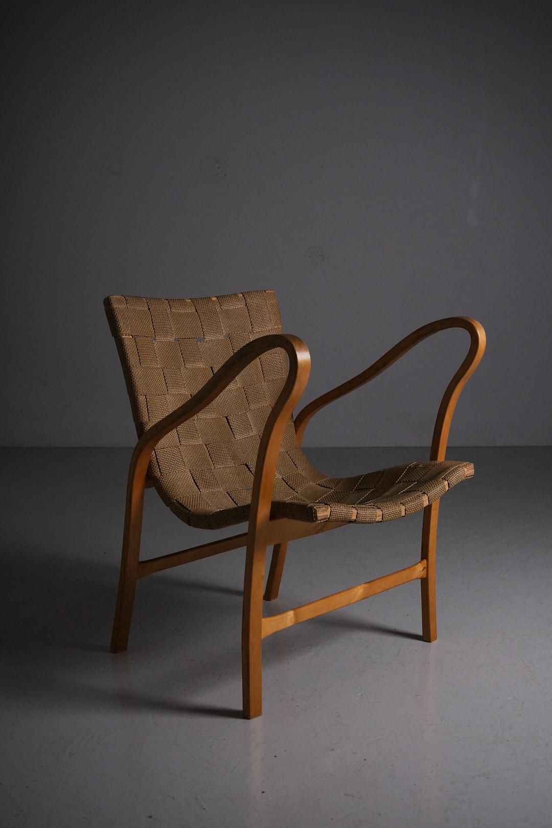 Sculptural armchair designed and produced by Gustav Axel Berg during the 1940s. 

Model 'Tösen' was designed in 1942. Unique design with its sculptural armrests. Made in birch and hemp webbing.