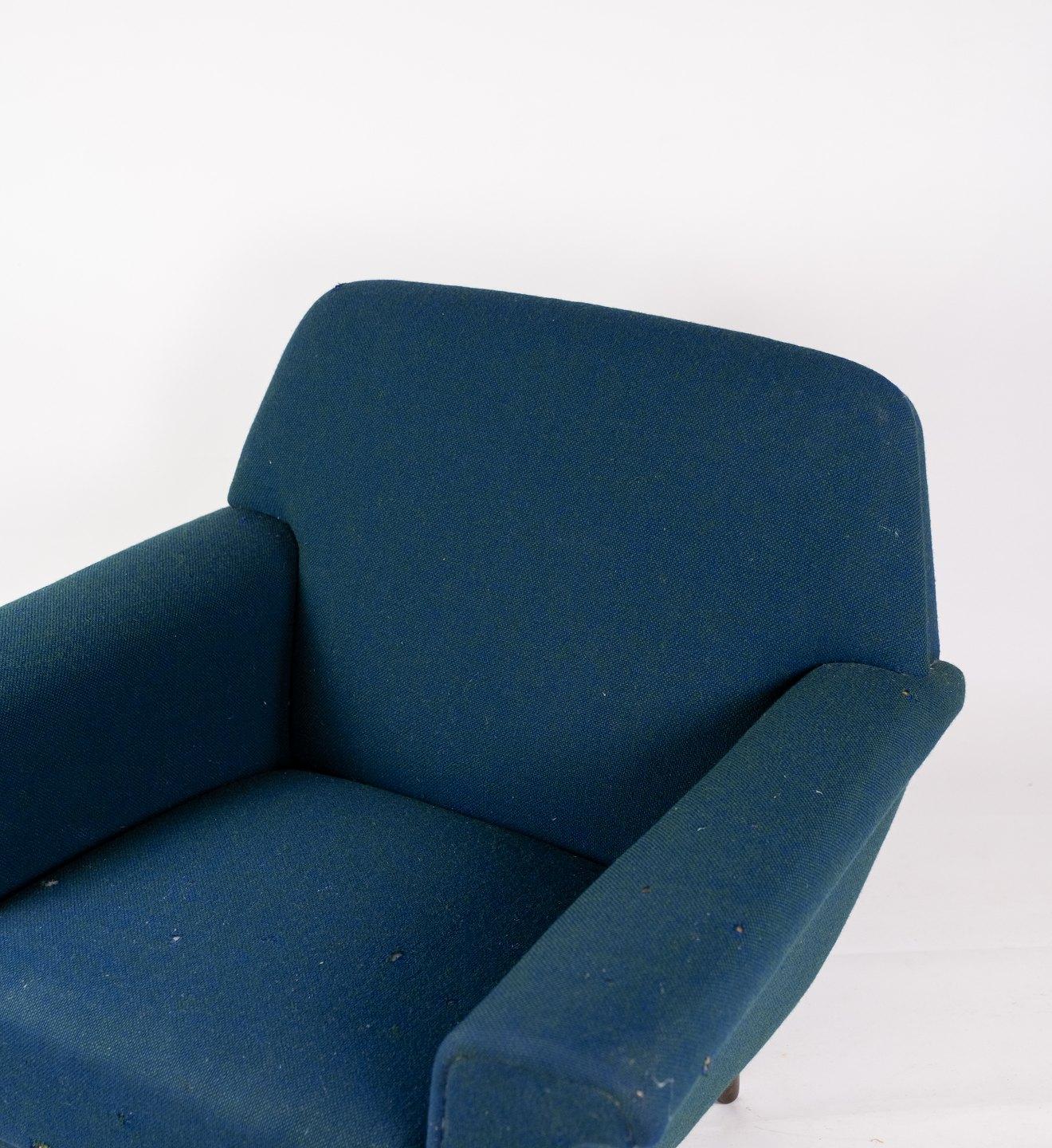 Fauteuil tapissé de tissu en laine bleu foncé et pieds en bois foncé, de conception danoise fabriqué par Fritz Hansen dans les années 1960. La chaise est en excellent état vintage.
Mesures : H 75 cm, L 88 cm, P 50 cm et SH 38 cm.