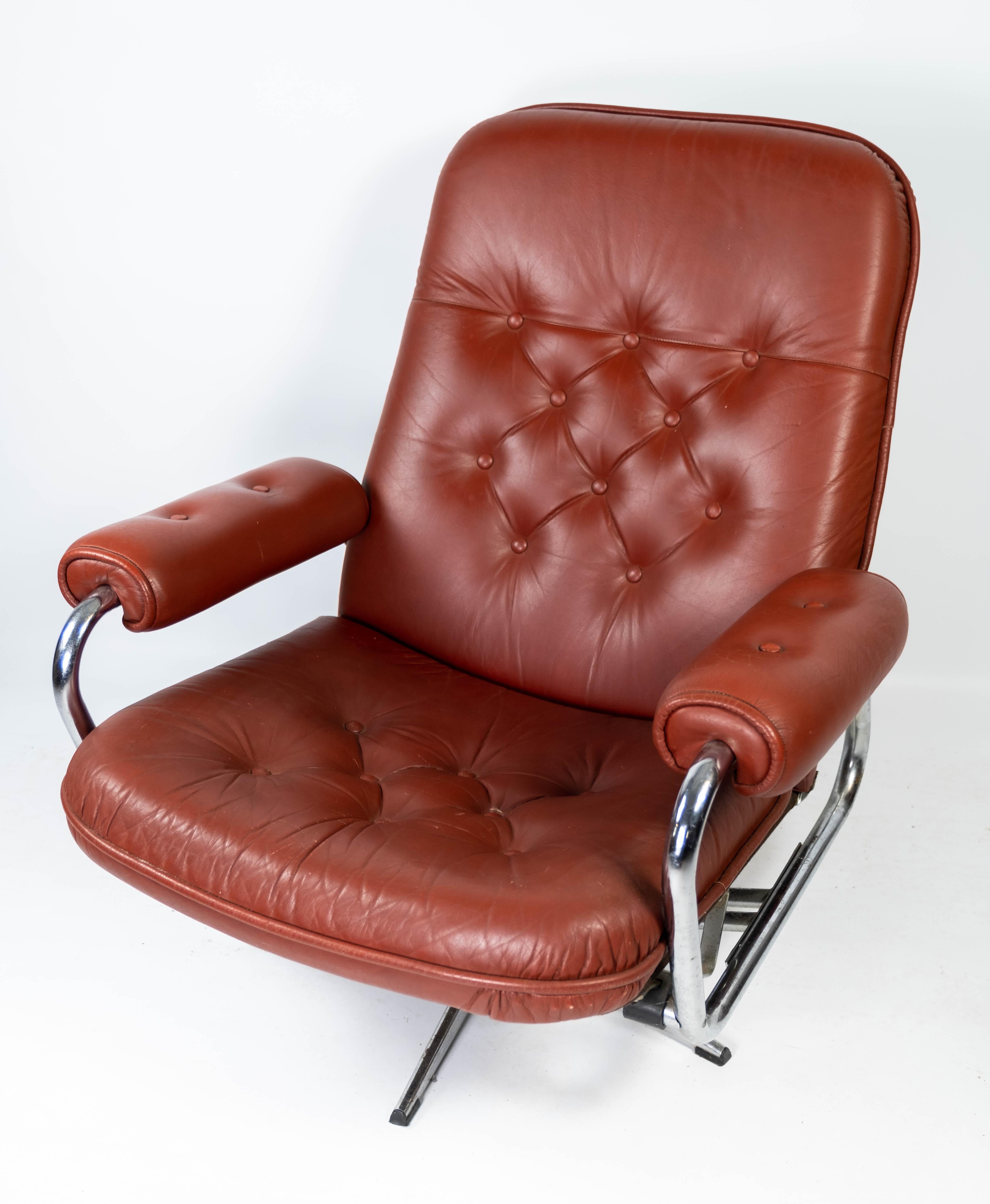 Armchair upholstered with red leather and frame of metal, of Danish design from the 1960s. The chair is in great vintage condition.