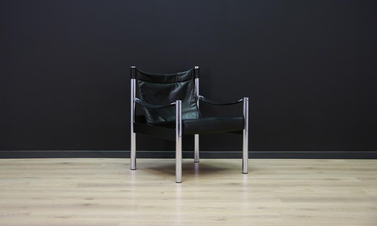 Stylish armchair from the 1960s-1970s, a beautiful minimalistic Danish design. Armchair covered with original leather (color - black). The construction is made of chromed metal. Preserved in good condition (visible scratches on the skin, minor