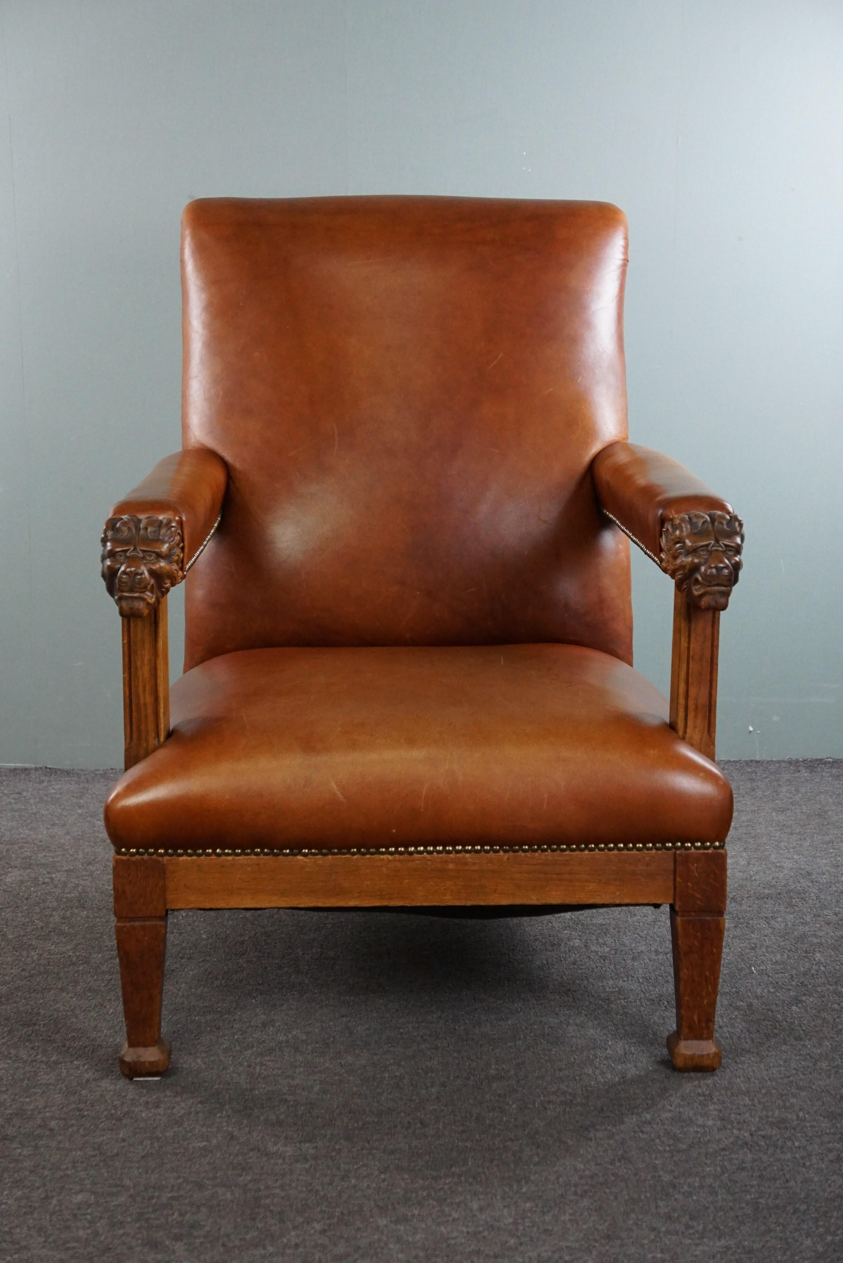 Offered is this stately antique Dutch armchair adorned with lion heads, which has been reupholstered in cognac-colored cowhide and finished with decorative nails.

Can you already imagine this armchair in your interior? It wouldn't surprise us if it