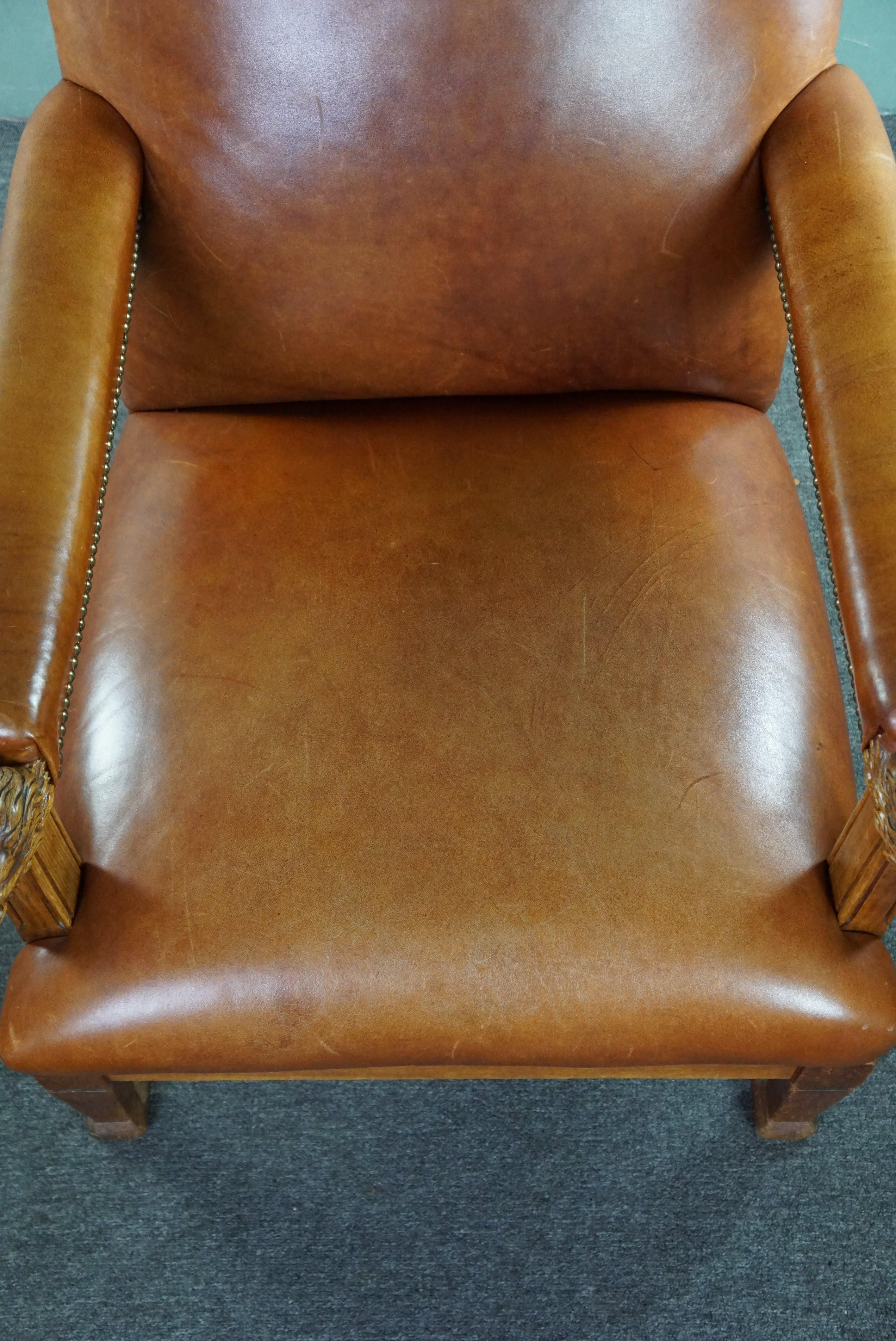 Leather Armchair with lion heads reupholstered in cognac-colored cowhide For Sale