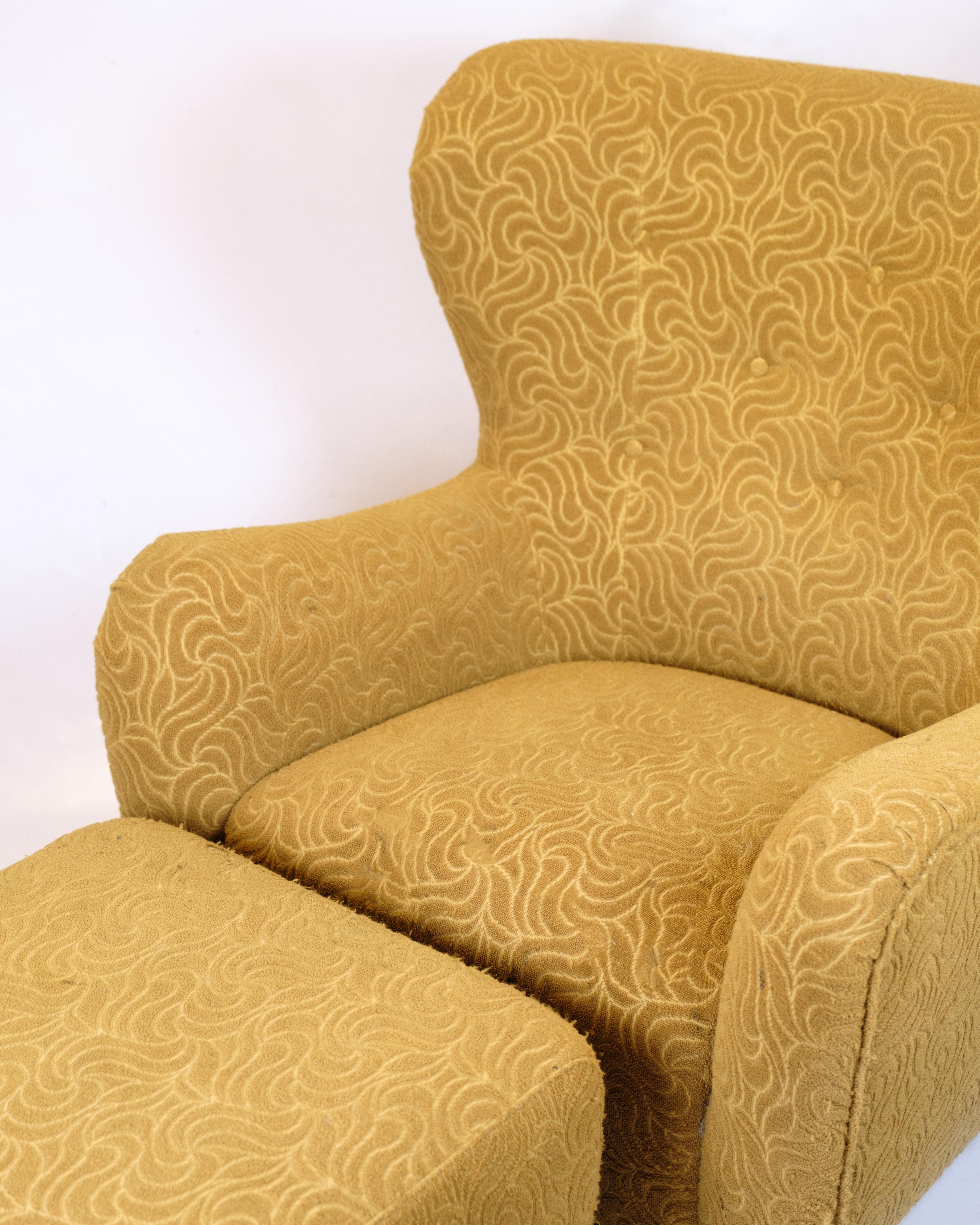 Armchair with ottoman from the 1940s. Upholstered in patterned yellow fabric with black legs. Classic design with high comfort.

— Type: Armchair with ottoman
— Materials: Upholstered in patterned yellow fabric, black legs
— Period: 1940s
— Armchair