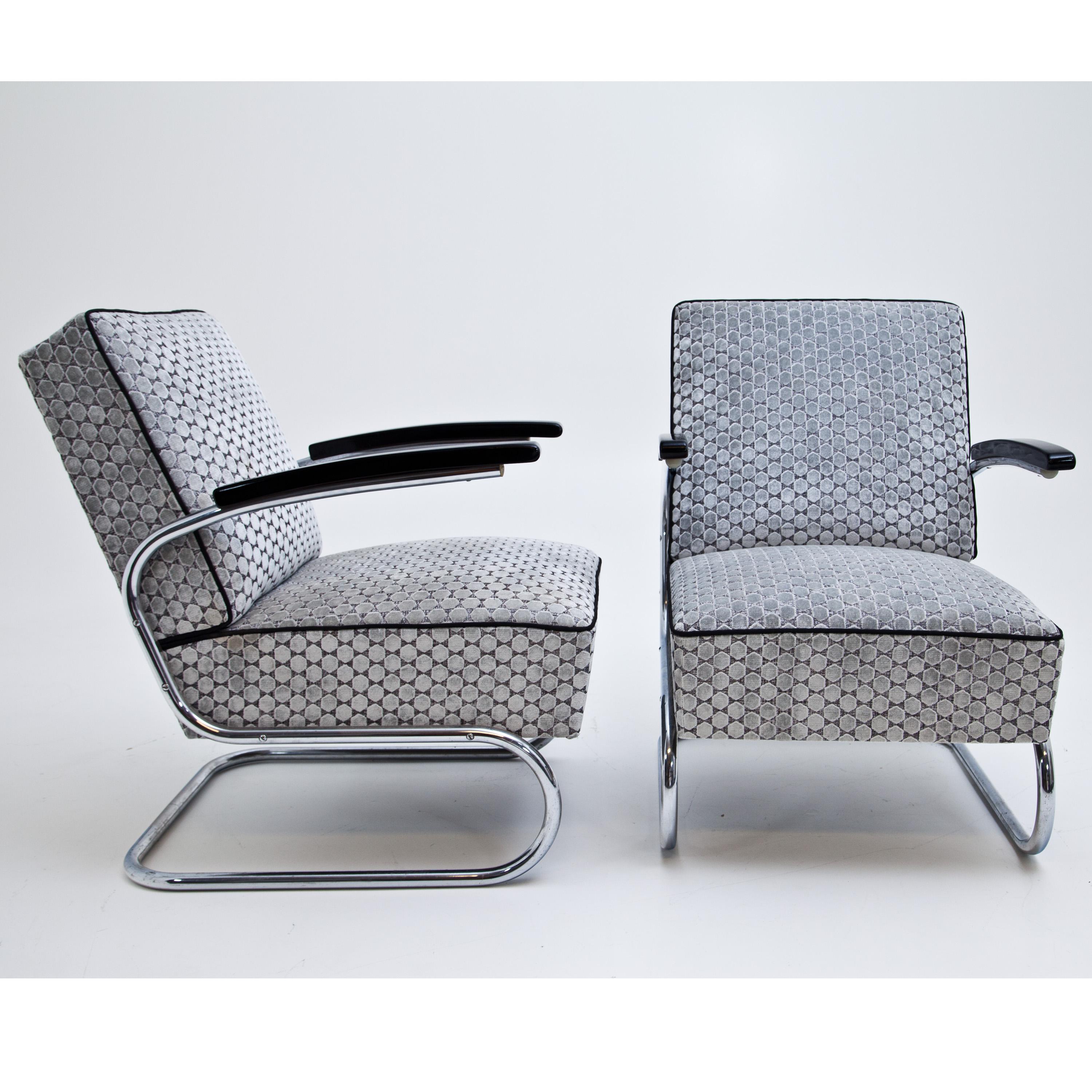 Pair of armchairs after Thonet’s S411 with S-shaped bent tubular steel frame and wooden armrests. The thickly upholstered seats and backrests are newly upholstered with a high quality patterned grey fabric.