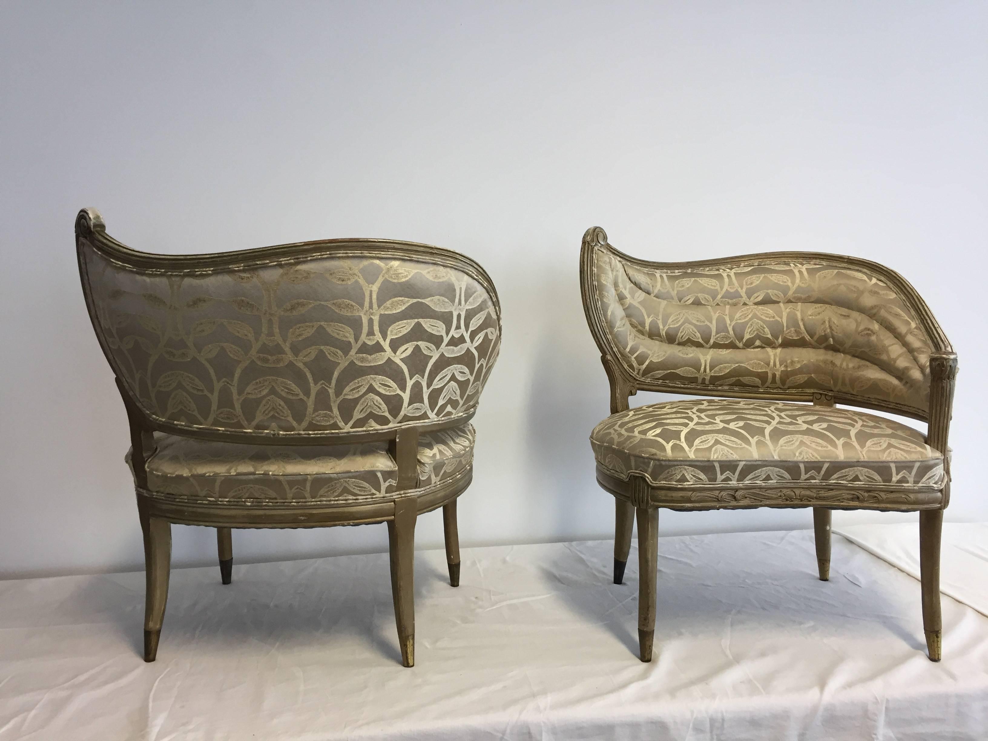 Pair of decorative armchairs, back together with armrest in wing shape,
New upholstered In Rubelli fabric, gilded wood with carving details, each leg has a brass cup.