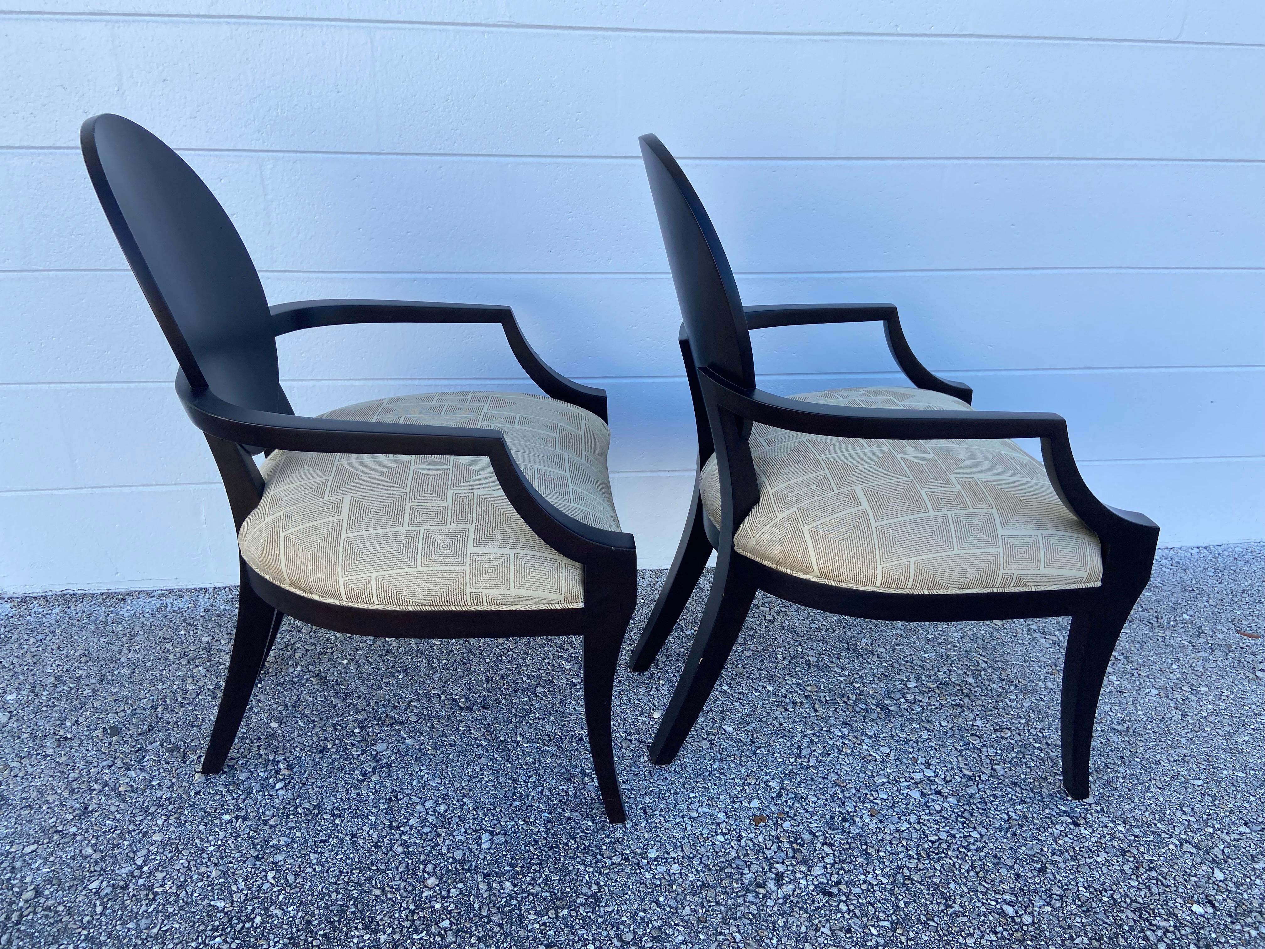 A pair of Barbara Berry inspired oval frame chairs. These pieces are unique because of the design and quality. We have a total of 10, but we are selling 2 at a time. They are wood, with a unique arm detail on the back. Chocolate brown/black with