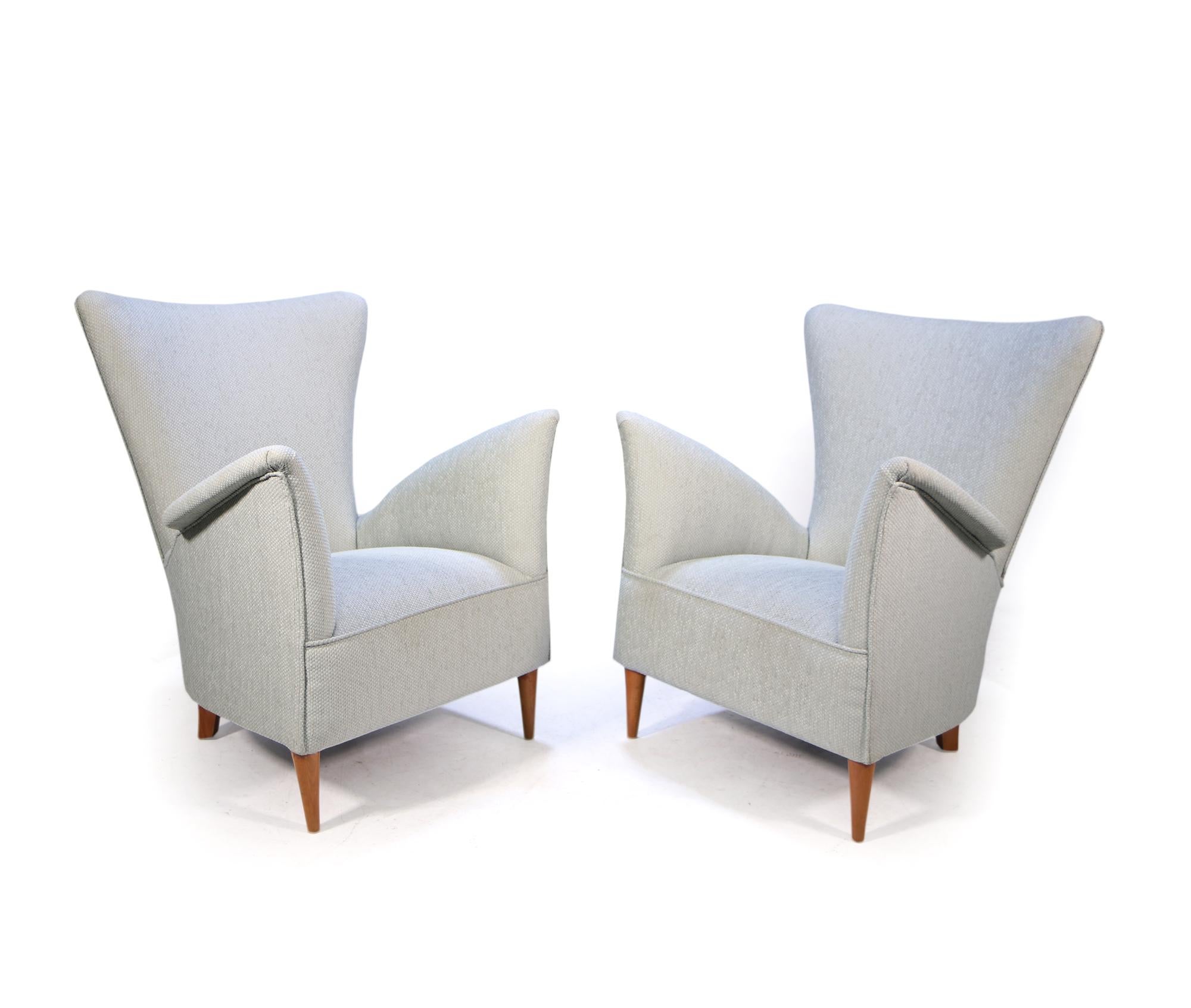 A Pair of armchairs designed by Gio Ponti for the Hotel Bristol in 1954, this set has been fully upholstered, coil sprung seat over hardwood frame covered in heavyweight mint and silver colour geometric fabric and stands on a simple set of light